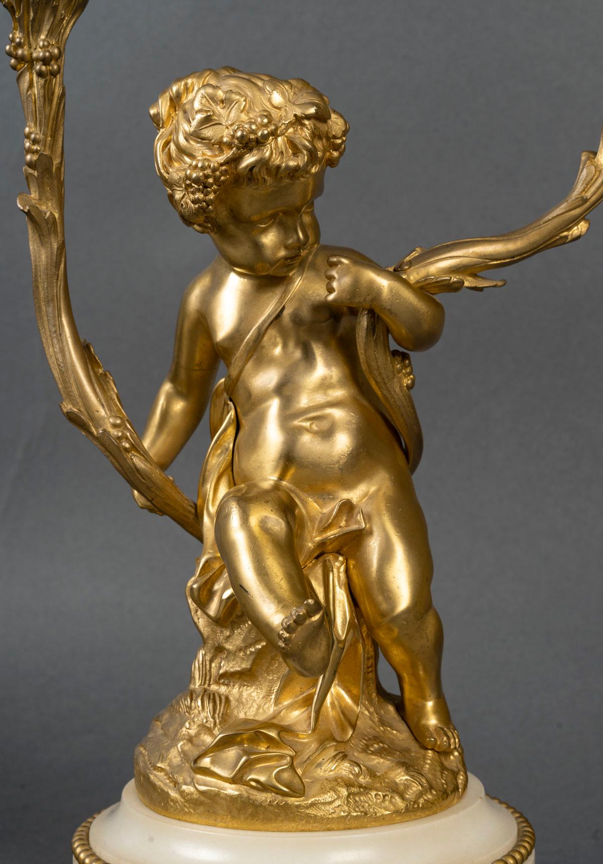 Importante pareja de candelabros de bronce dorado y mármol del siglo XIX con bebés, época Napoleón III

Pareja de candelabros de ormolina y mármol blanco Napoleón III del siglo XIX, firmados Clodion, estilo Luis XV.
Alto: 40 cm, Ancho: 27 cm, Fondo: