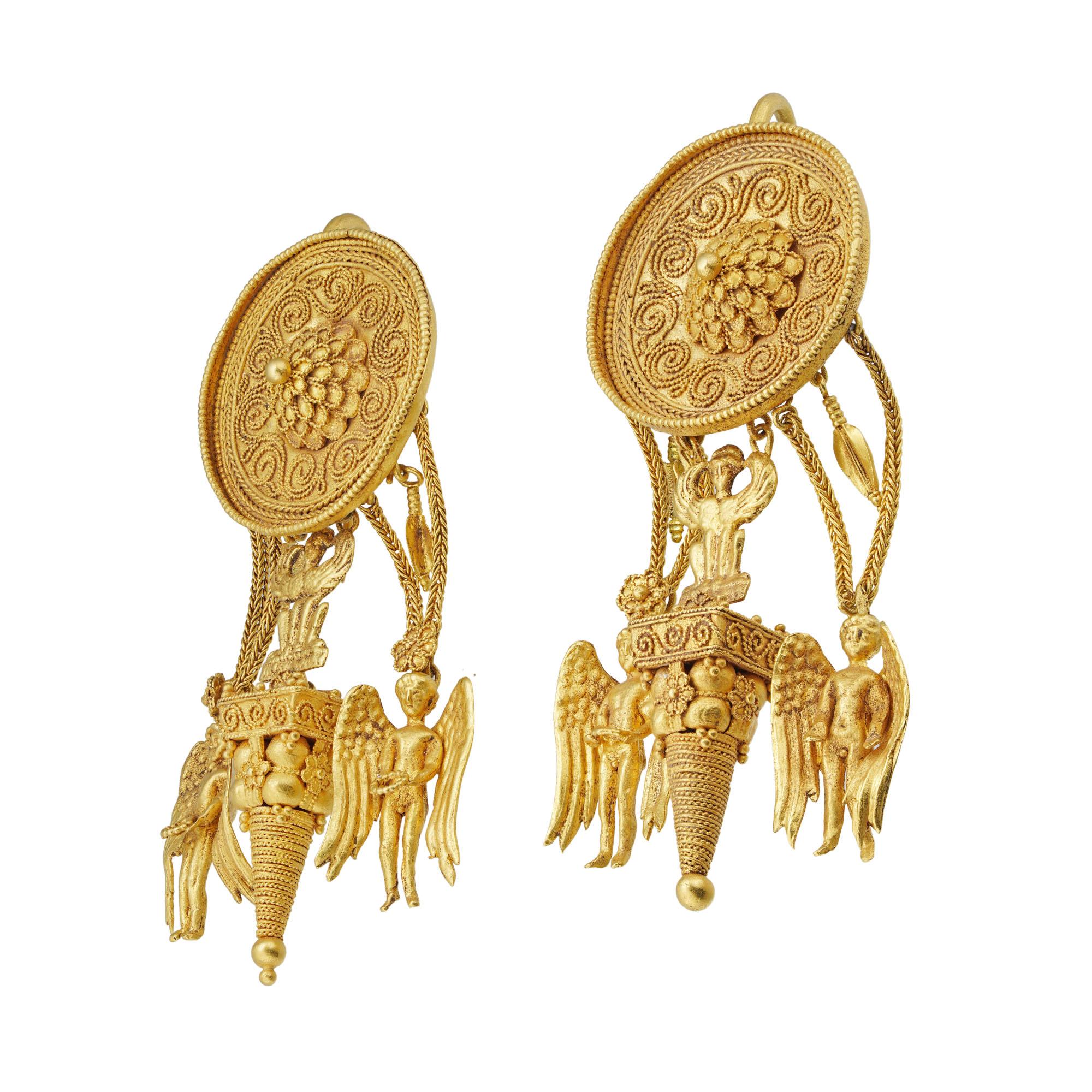 Un'importante coppia di orecchini ellenistici in oro, ciascun orecchino con un disco decorato centralmente con una testa di fiore a quattro livelli con petali convessi con bordi decorati da fili ritorti, circondati da decorazioni in filigrana a onde