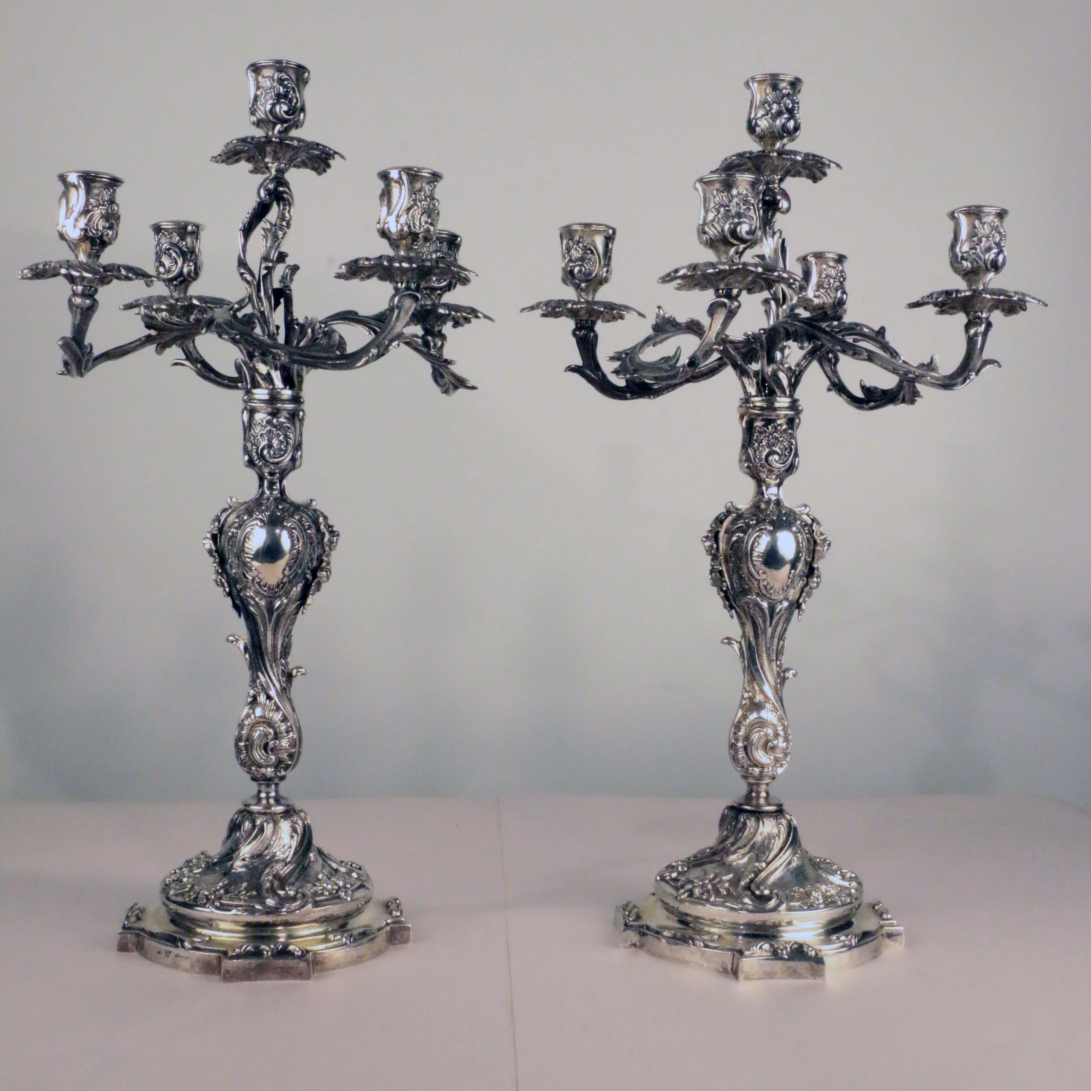 These are cast and are both large and weighty. The four branches are worked with shells and scrolling acanthus, a motif repeated on the vase-shaped stem. And echoed on the raised base, on a circular foot.

This sumptuous pair are cast and finished