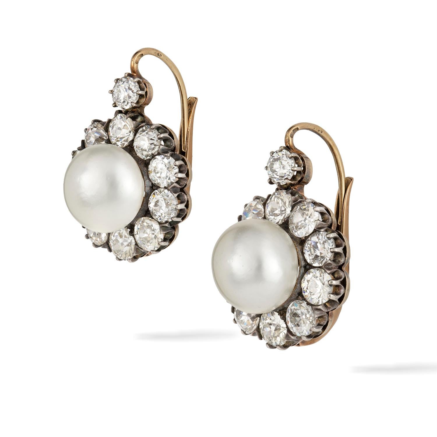 An Important pair of natural pearl and diamond cluster earrings, each button-shape pearl measuring 11.15-11.30mm in diameter, accompanied by report of the German Foundation for Gemstone Research no 025323 stating that the pearls to be natural and of