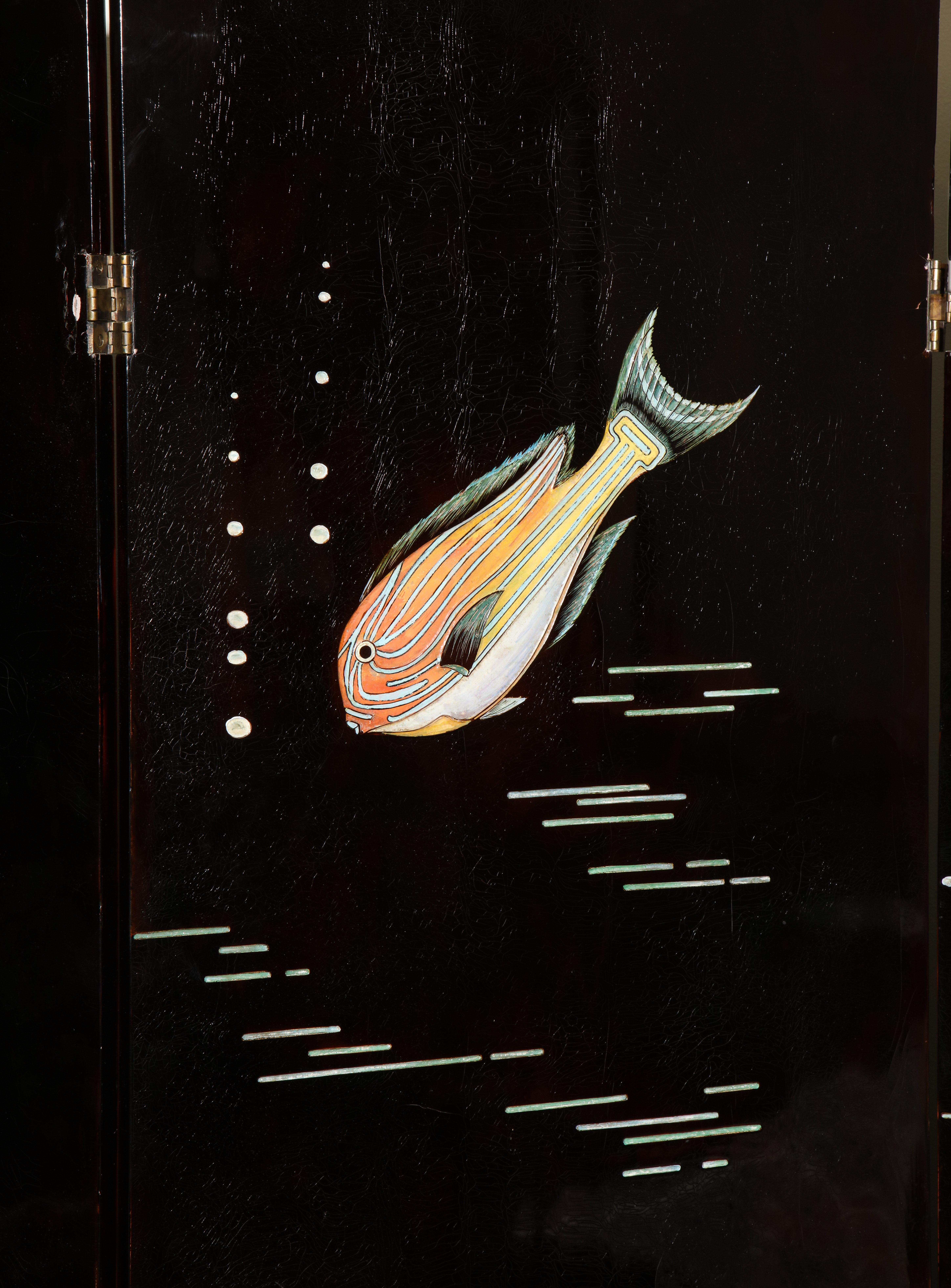L'écran laqué couleur écaille de tortue avec des poissons assortis incisés et polychromés, signé d'un monogramme en creux LJ

Chaque panneau fait 22,5