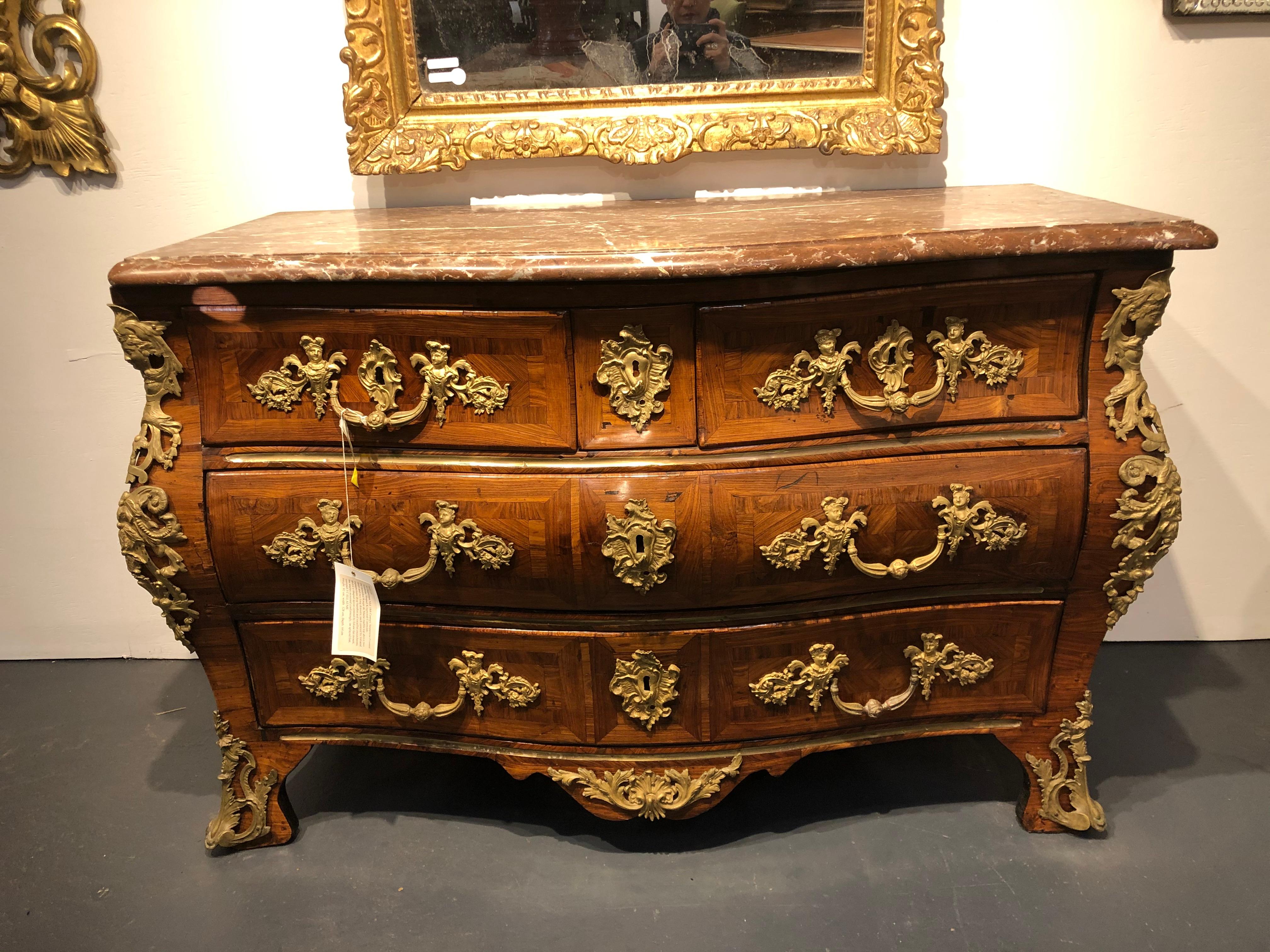 An Important Serpentine Fronted Tombeau Shaped Kingwood Commode, 18th Century

The moulded Rouge de Maine marble top above two short and two long drawers, each centred by foliated espagnolette drop handles and rocailles escutcheons, above a shaped