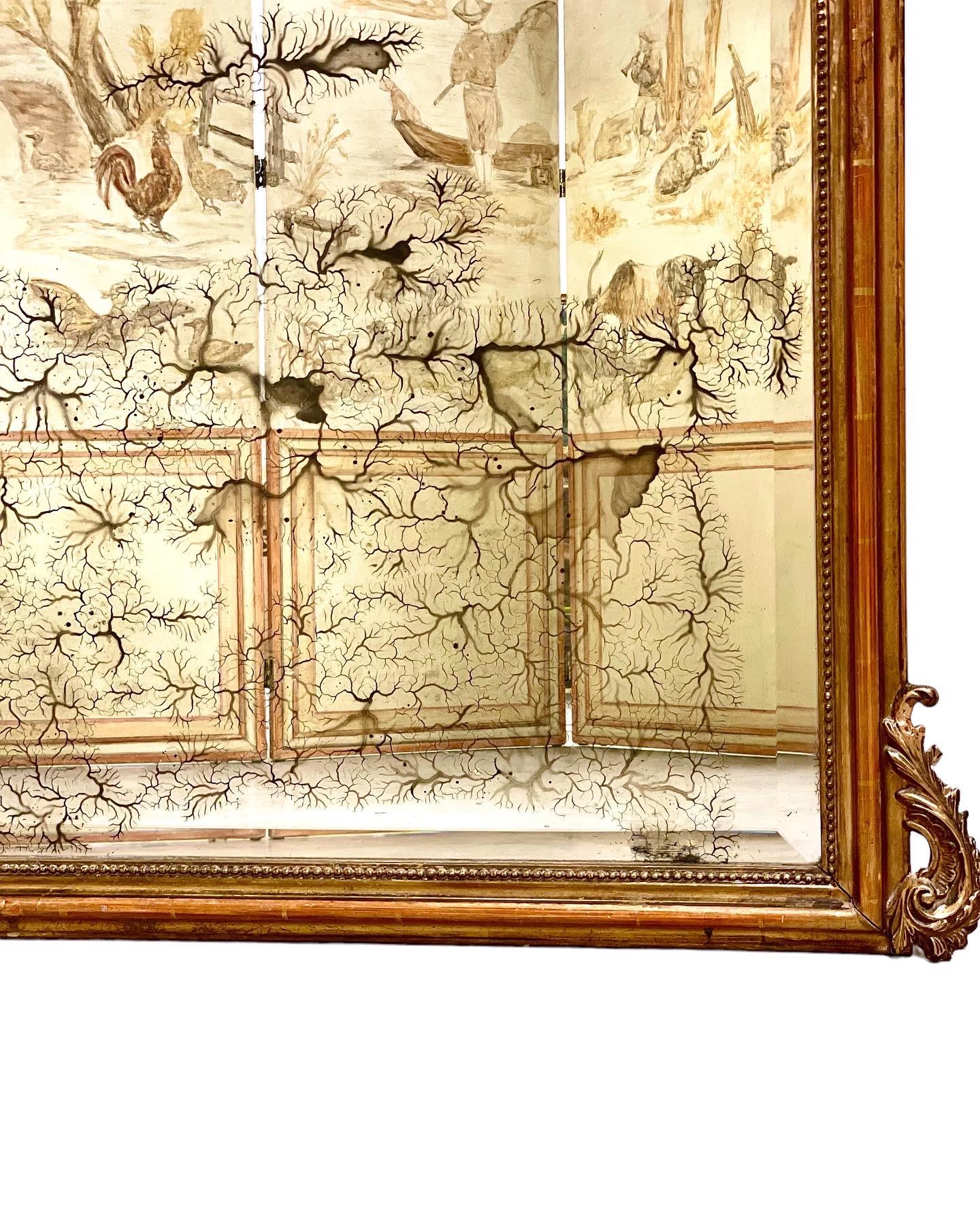 Imposant miroir à trumeau doré de style Louis XV d'époque Napoléon III, datant du 19e siècle. Surmontée d'un exubérant écusson composé de feuillages et de coquillages stylisés, ainsi que de motifs Rocaille tourbillonnants, cette belle pièce présente