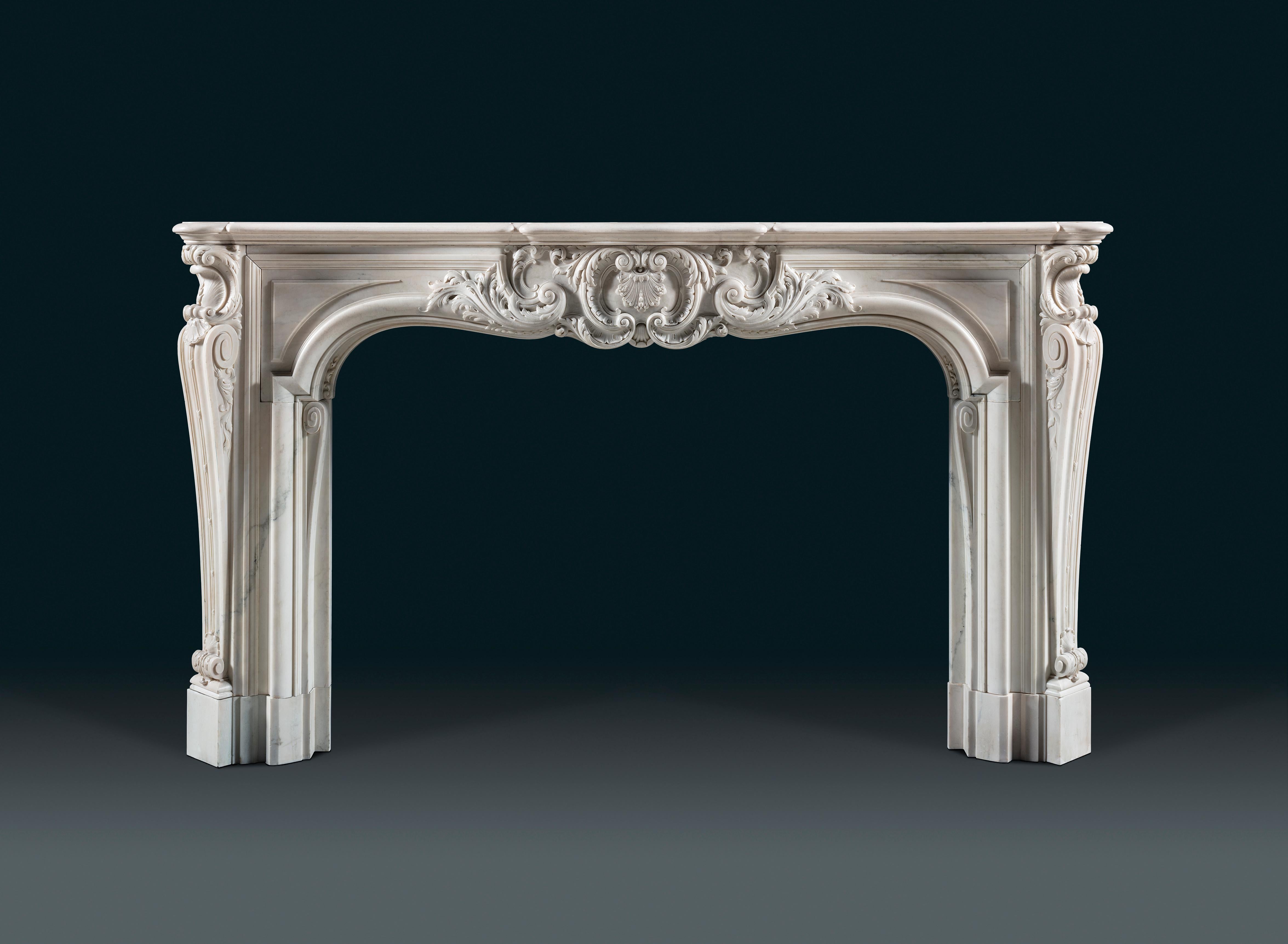 An imposing and highly important antique Louis XV period statuary marble chimneypiece of exceptional quality and generous proportion, the serpentine opening centred with an elaborate foliate Rococo cartouche with carved acanthus throughout, flanked