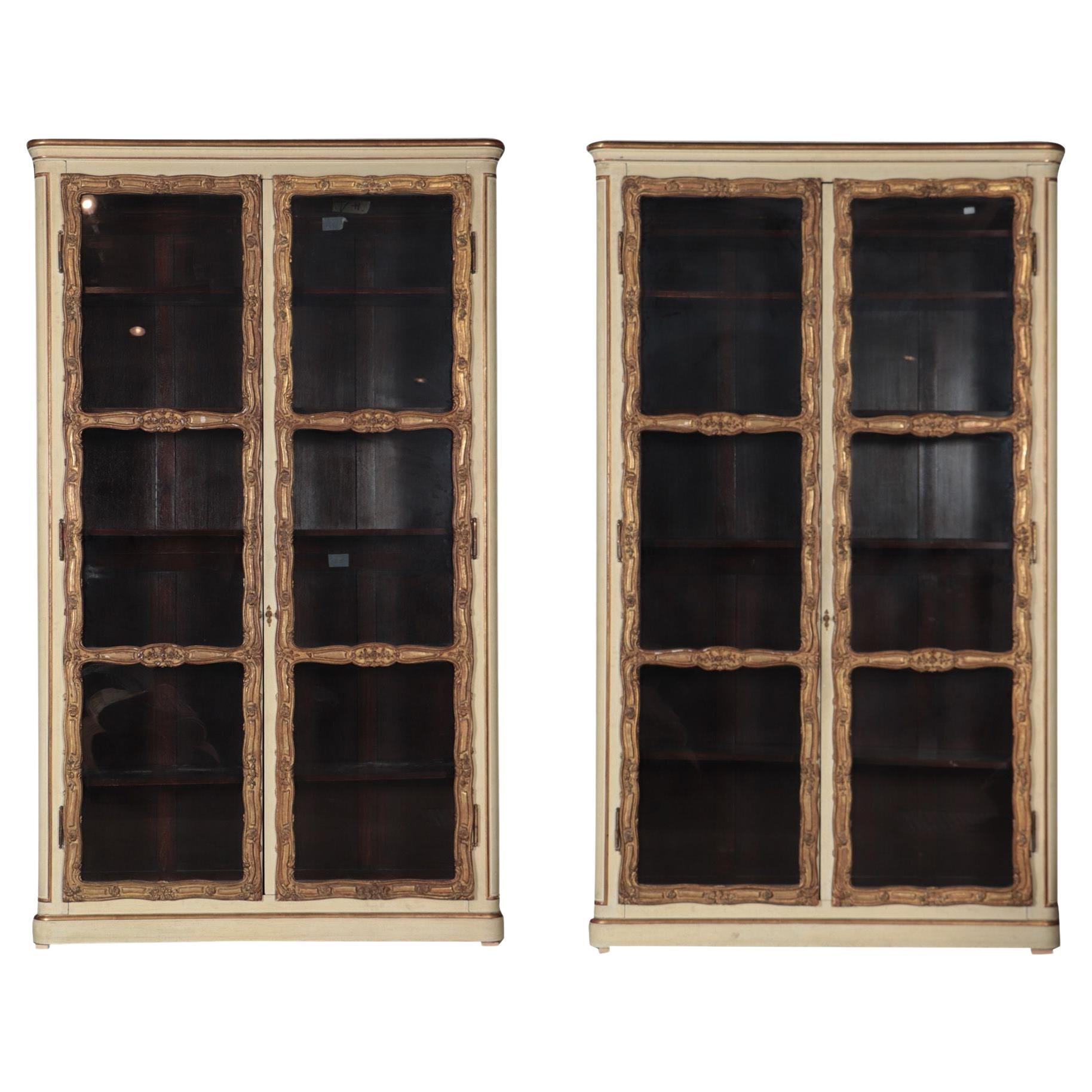 An imposing pair of cream painted and parcel gilt large bookcases, French, 19th