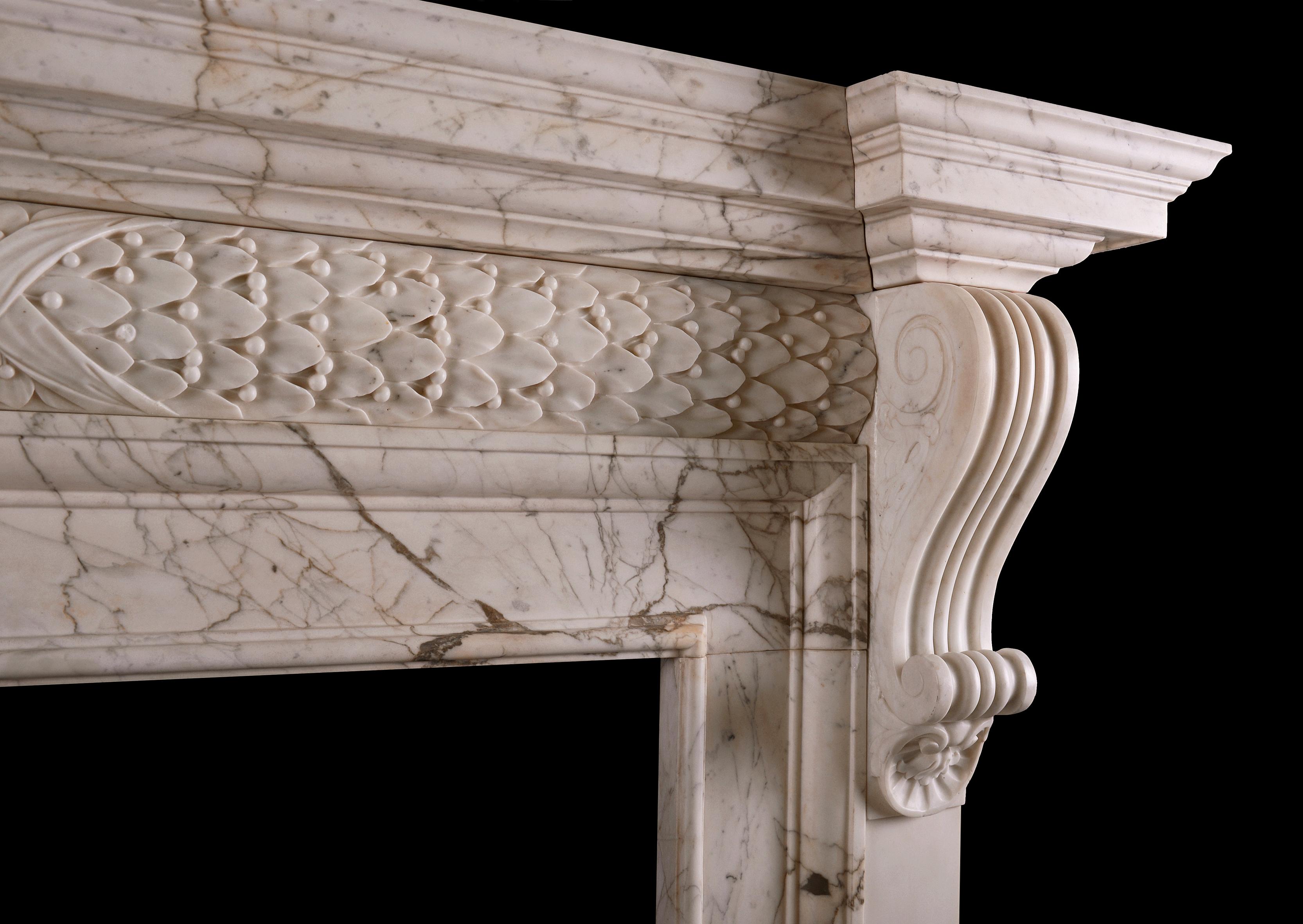 An imposing period Georgian fireplace in Calacatta Oro marble. The barrel frieze with foliage and berries throughout, tied with cross banded ribbons to centre. The jambs with scrolled carved brackets, surmounted by moulded breakfront shelf. 18th