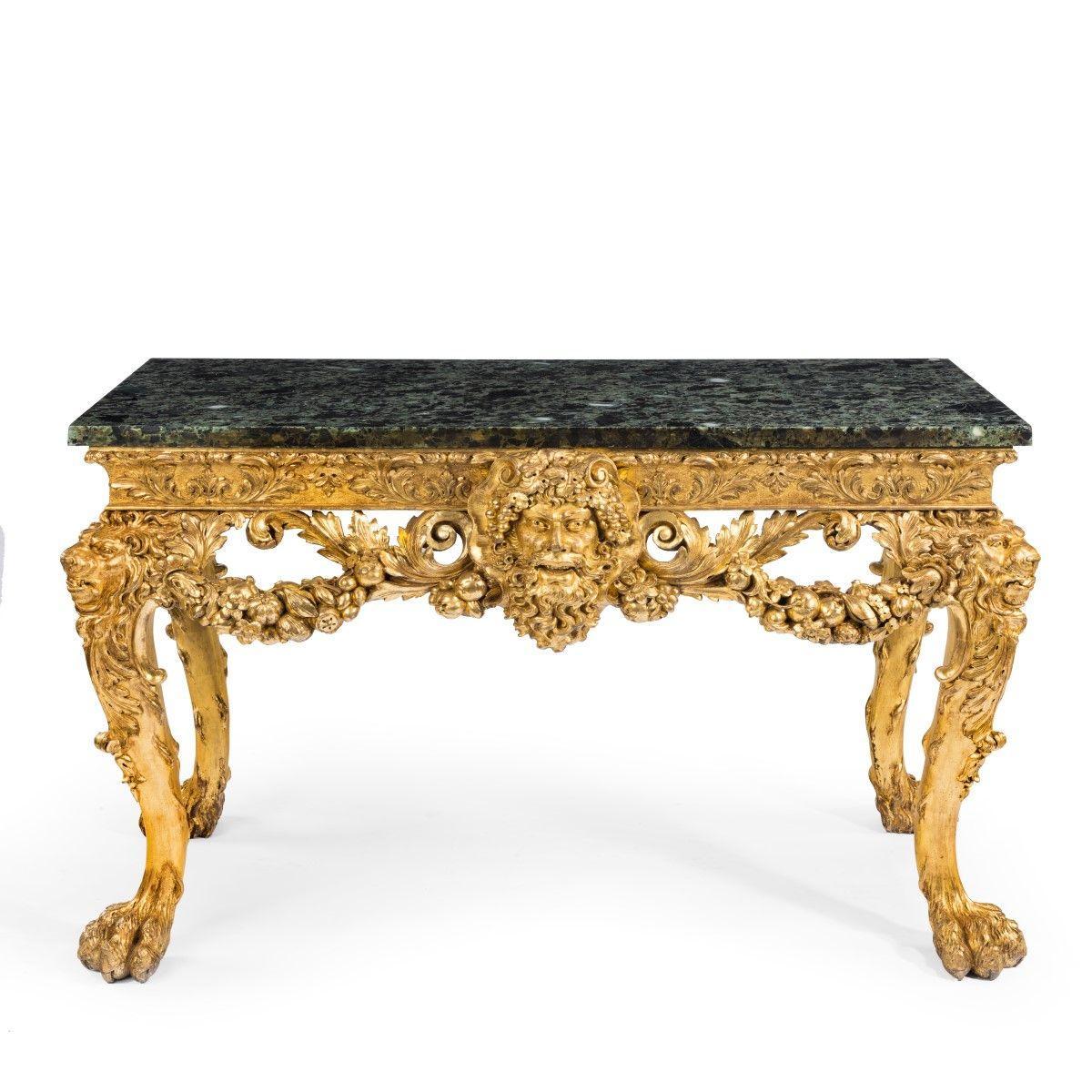 An imposing Victorian giltwood console table in the manner of William Kent, the rectangular serpentine marble top set upon a giltwood base superbly carved with scrolls and garlands heavy with fruit centred on a mask of Bacchus wreathed in vines, the