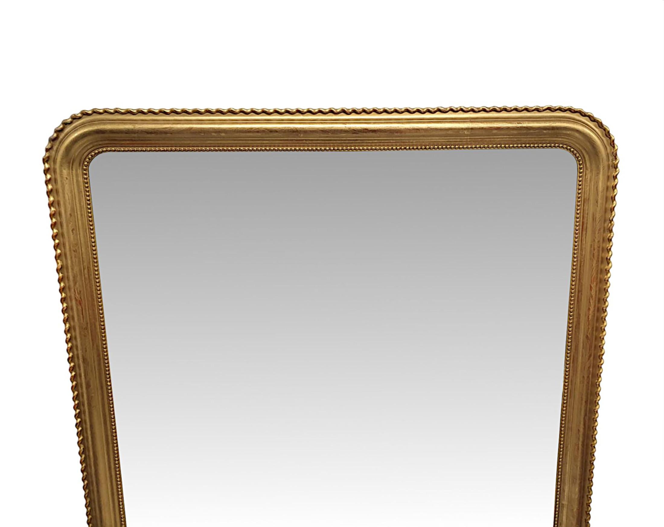 An impressive 19th century giltwood overmantle mirror of extremely large proportions. The mirror glass plate of rectangular form with curved detail to the top corner returns is set within a finely hand carved and beautifully simple, moulded and