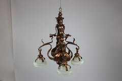 An impressive Arts and Crafts copper chandelier with original vaseline shades