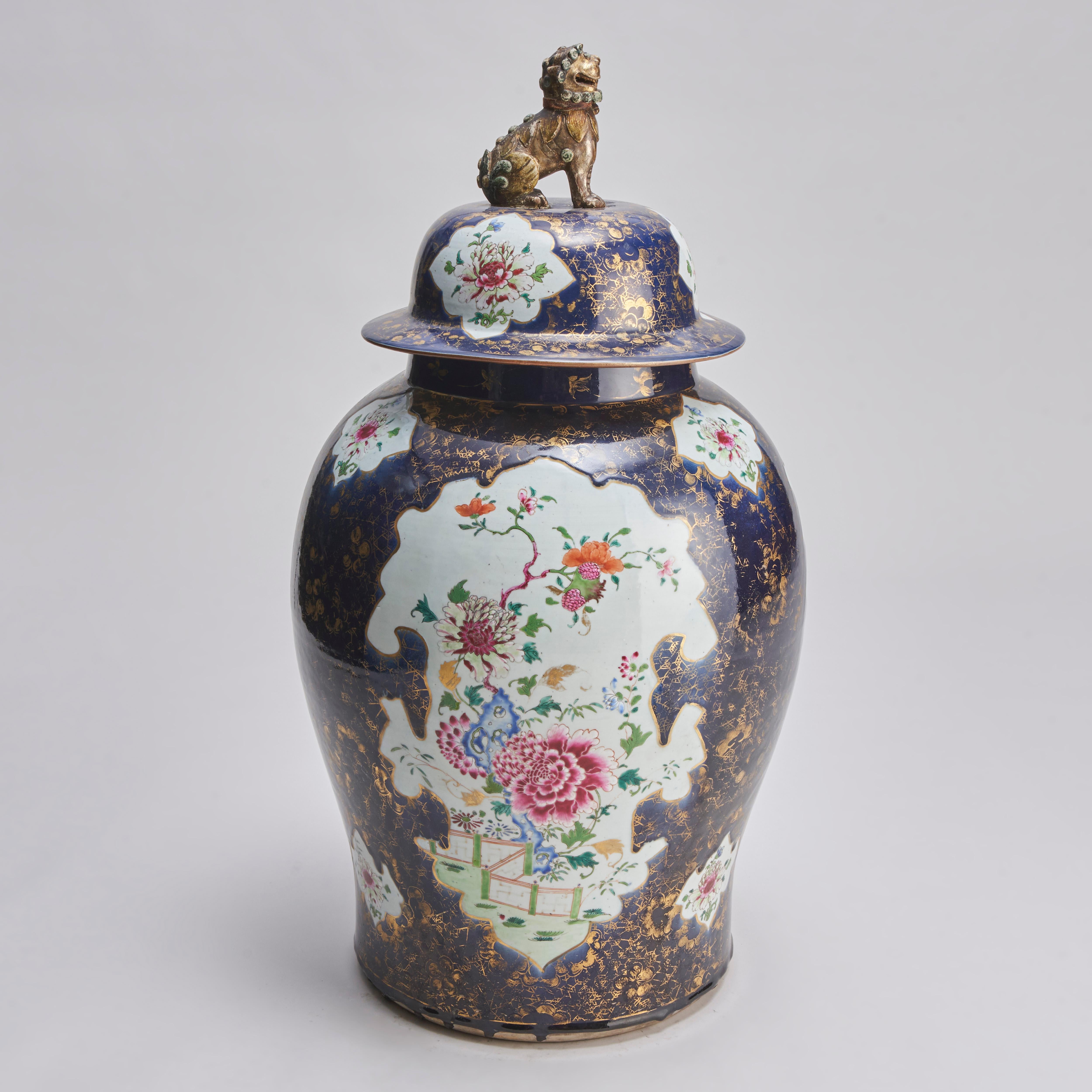 A large 18th century Chinese temple jar and cover with famille rose decoration of fantastical flowering shrubs on a powder blue ground with remnants of a spiderweb-like golden pattern.

The lid with matching decoration and a fine lion dog knop.

For