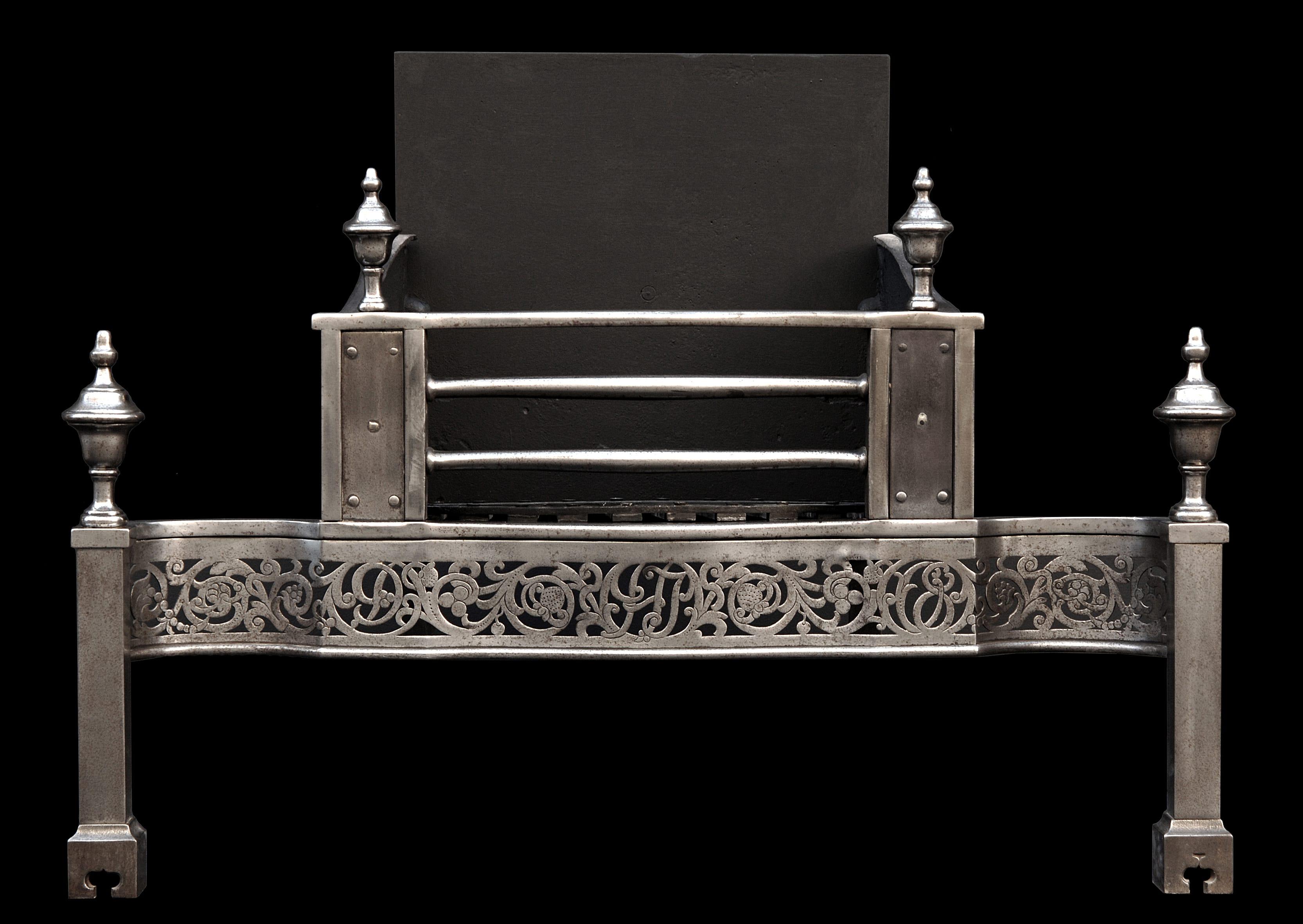 A 19th century Georgian style steel firegrate, with shaped pierced and engraved fretwork, large finials, riveted side panels, and cast iron back. An impressive piece.

Width At Front:	965 mm      	38