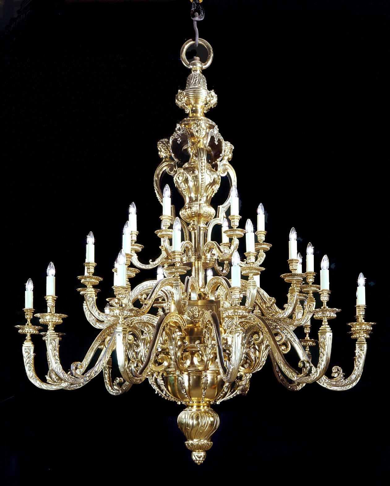 A magnificent large and impressive gilt bronze Regence style thirty-branch chandelier. 

French, circa 1890.

The massive central baluster stem finely cast with ‘C’-scrolls, cherub masks and acanthus, issuing three tiers of scrolling candle arms