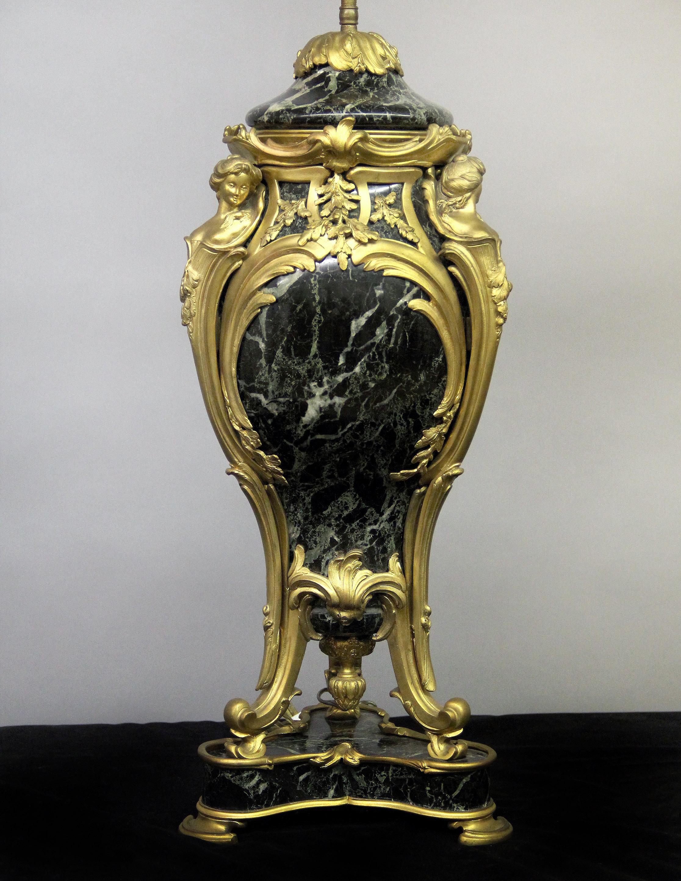 An impressive late 19th century gilt bronze mounted three-light marble lamp

The Verde green marble with bronze foliage designs, the corners with three lady busts leading down to scrolling legs on a marble base and bronze feet.

Measures: Total
