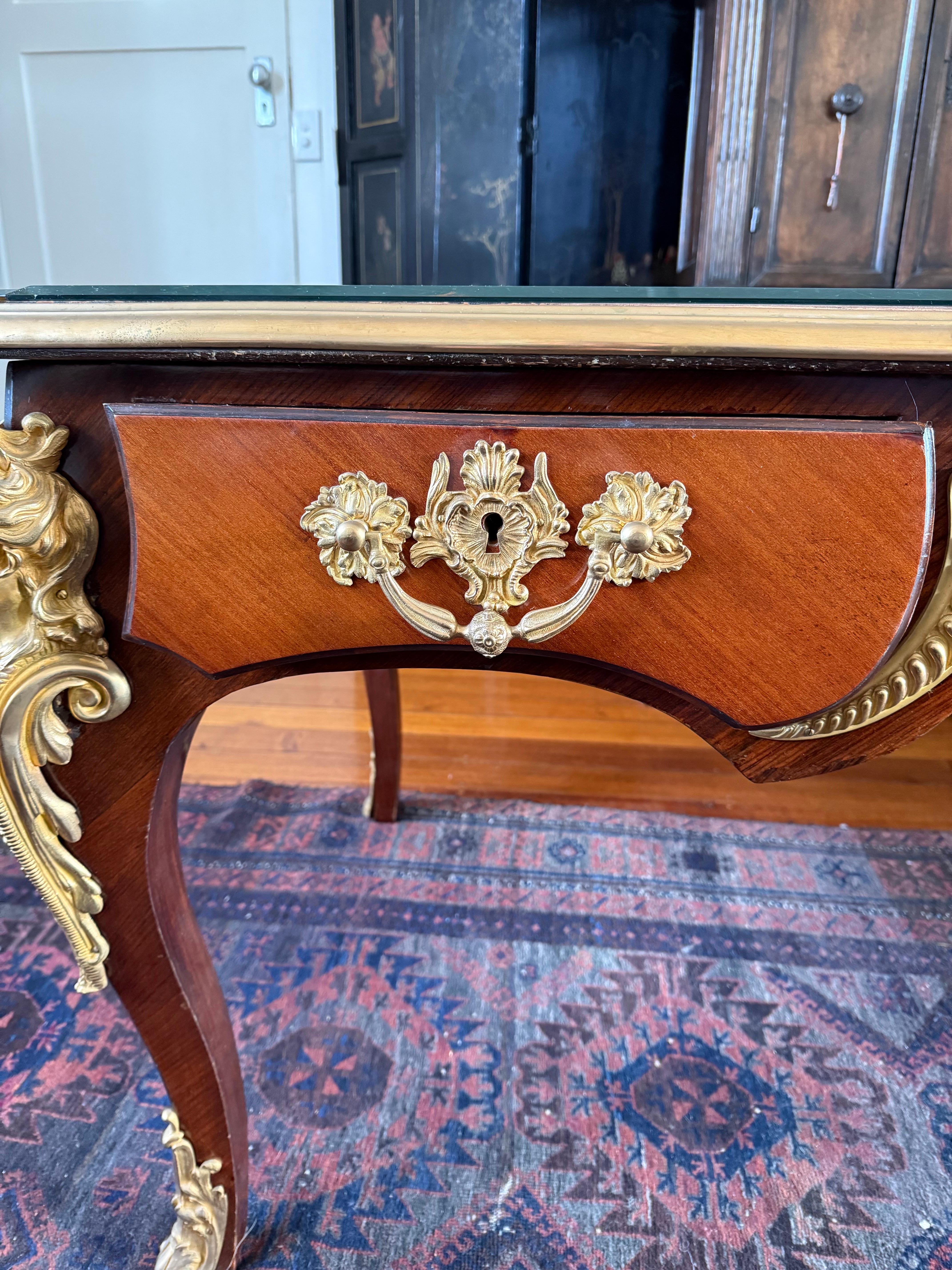 An Impressive Louis XV Style Gilt Bronze Mounted Bureau Plat, 19th/20th Century

Description:
With three drawers, dummy to the reverse and raised on cabriole legs, with gilt bronze trims, cast foliate handles, demi figures and sabots.

Provenance: