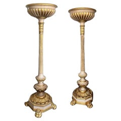 An impressive pair of gilt and painted uplighters