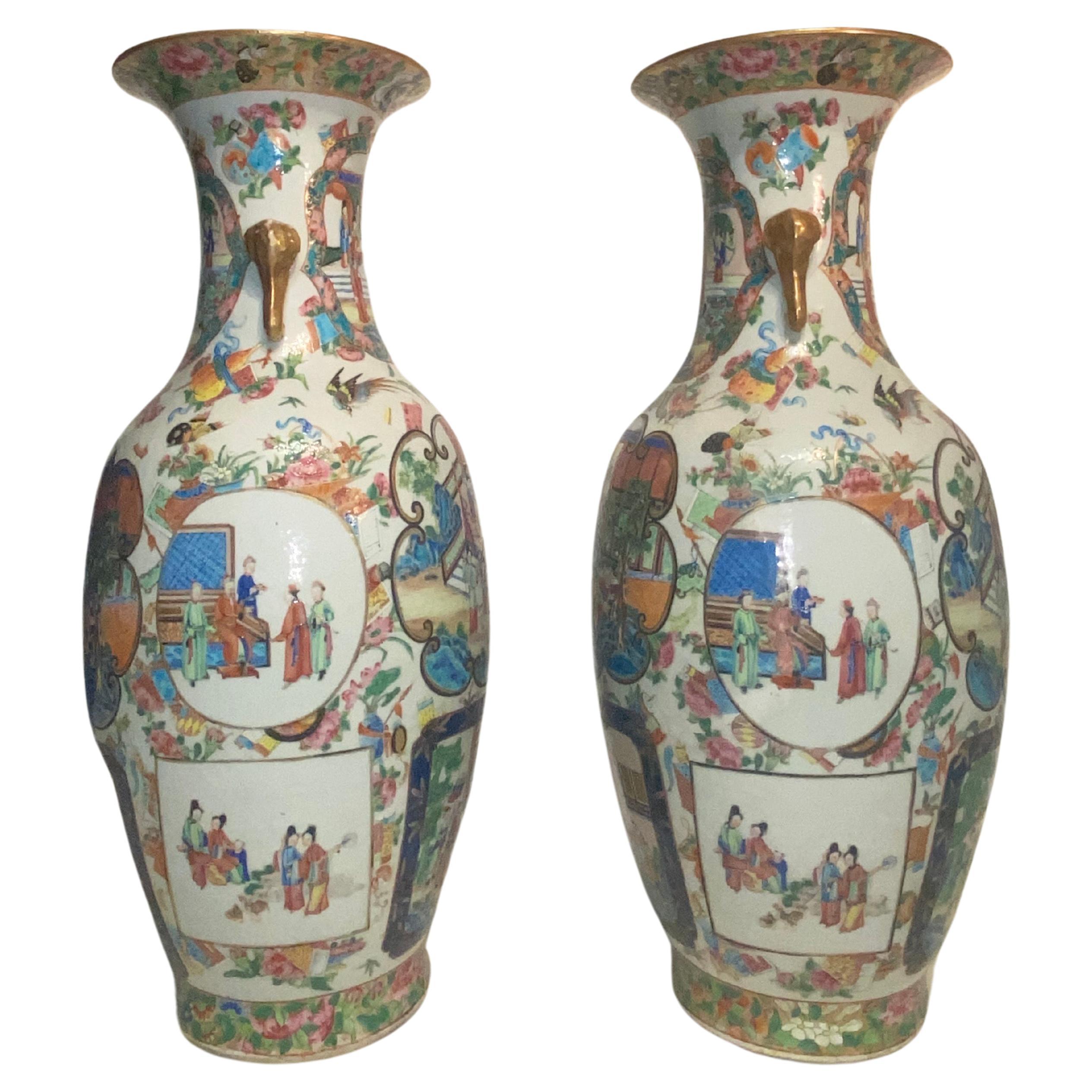 An impressive high quality pair of Cantonese Famille Rose medallion vases. Each having wonderful bold colours, the inset hand painted panels depicting interior scenes of courtiers and their attendants, bordered by classical motif, flowers and