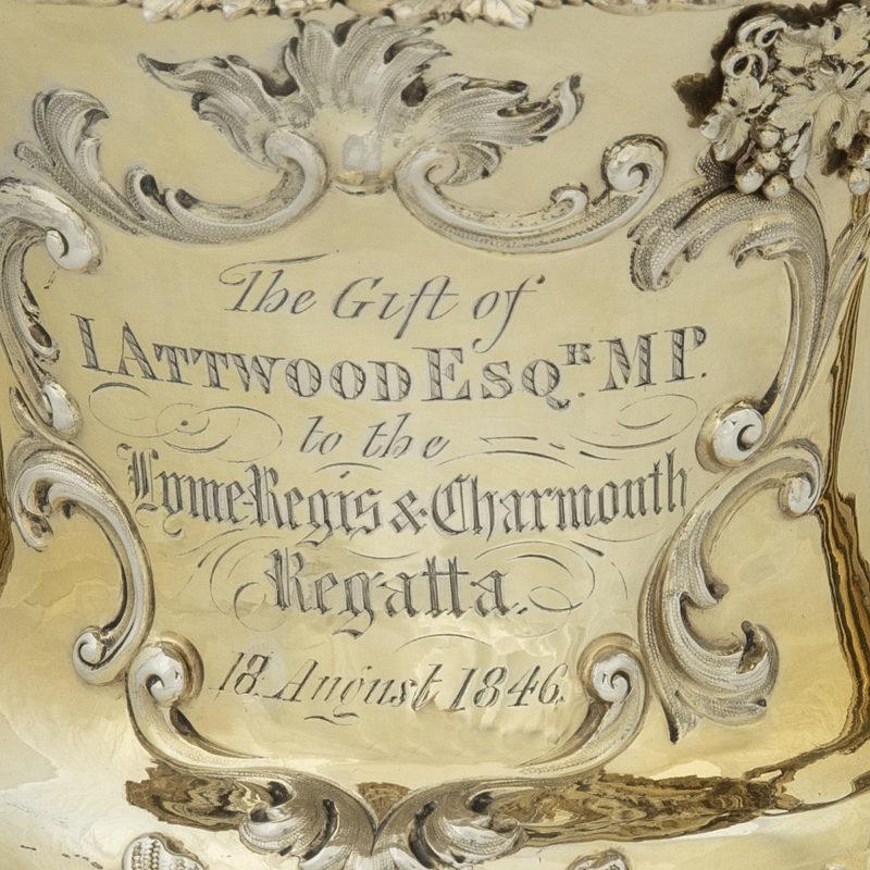 An impressive silver gilt Lyme Regis & Charmouth Regatta Cup for 1846 presented by John Attwood M.P. made by Hunt and Roskell, in the form of a classical footed urn with paired handles and a domed lid surmounted by a dolphin, engraved throughout