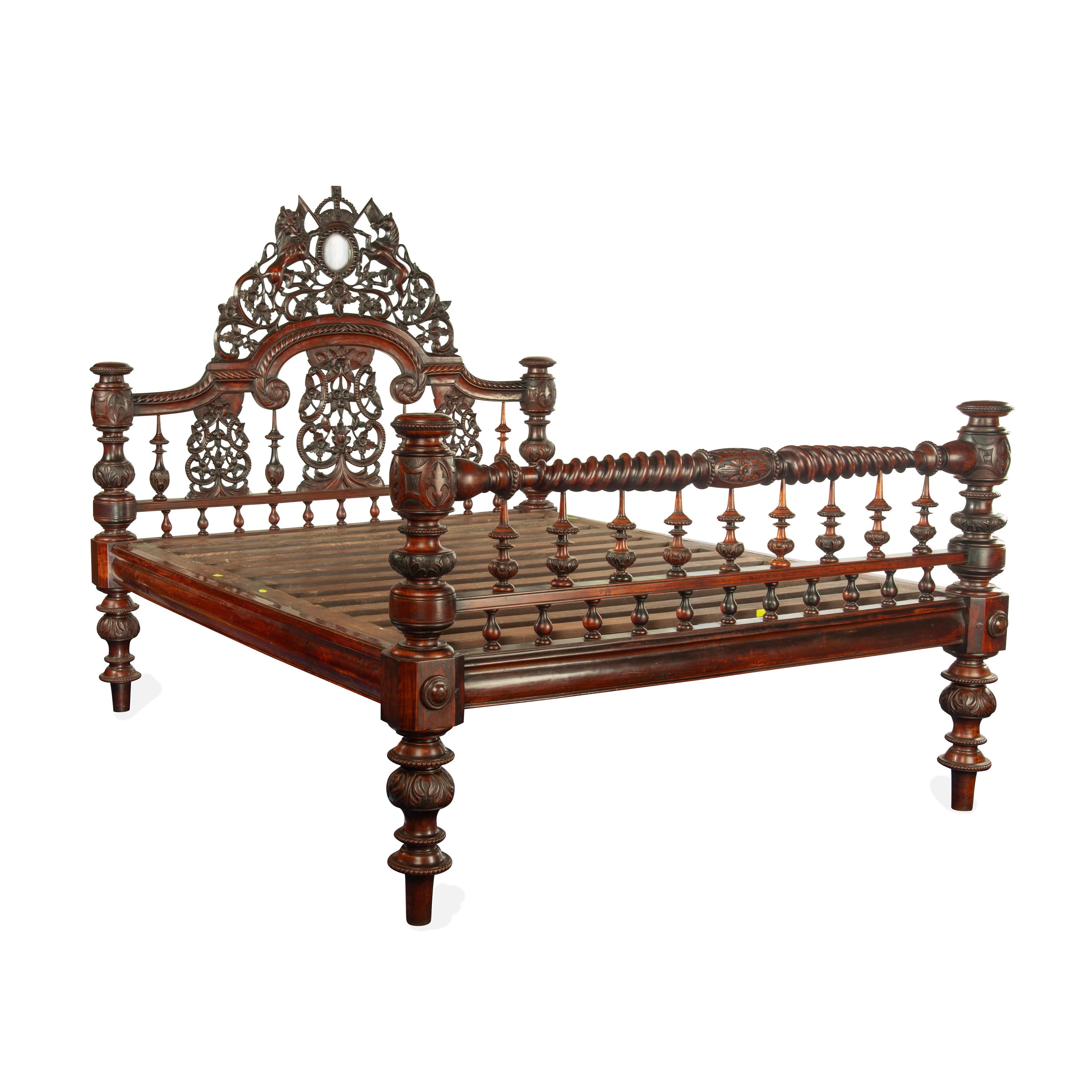 An impressive sissoo wood Anglo-Indian four poster bed, of rectangular form with a central openwork cresting, and splat, showing a naïve carving of the Coat of Arms of Great Britain, the lion and unicorn holding flags and flanking a Royal crown