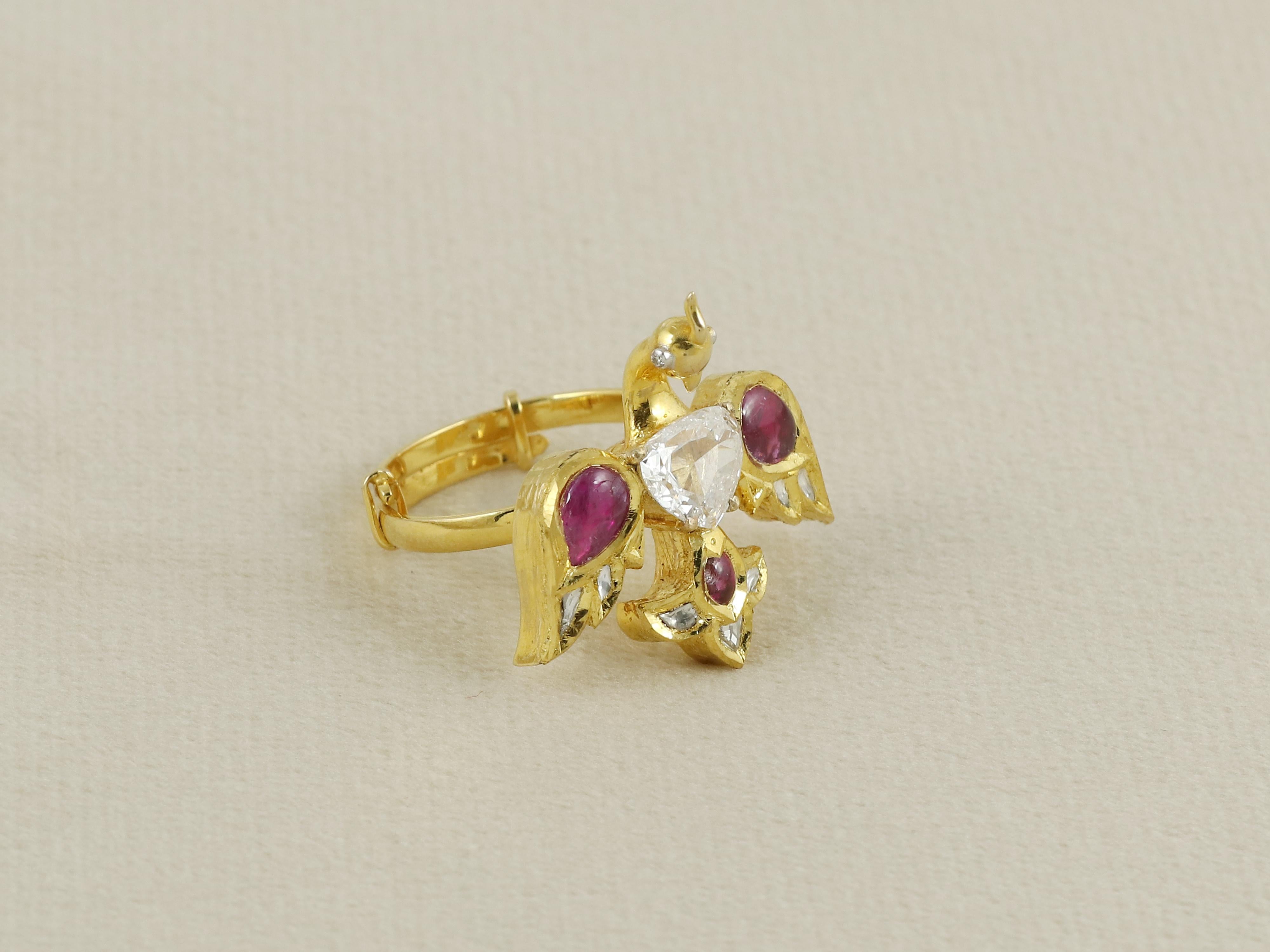 Ein exquisites Schmuckstück, das die Anmut des indischen Nationalvogels zelebriert. Dieser vom Pfau inspirierte Ring ist handgefertigt aus 18-karätigem Gold und lässt sich dank seines größenverstellbaren Designs vielseitig tragen. In seinem Zentrum