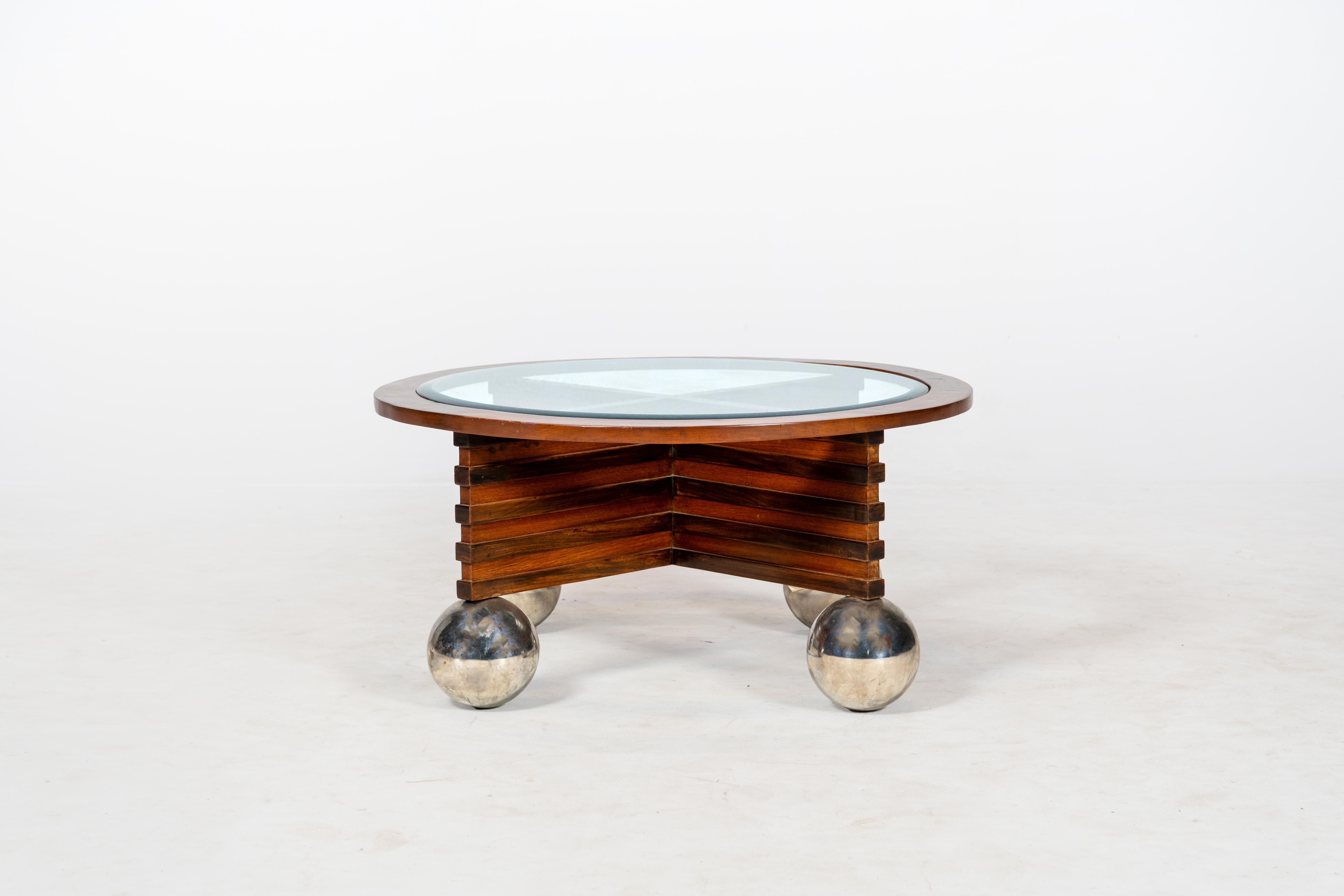 A very bold statement piece, this vintage Art Deco coffee table combines sculptural design with functional elegance. The circular wooden frame features a central cross-support beneath a clear glass top, allowing the geometric structure to shine