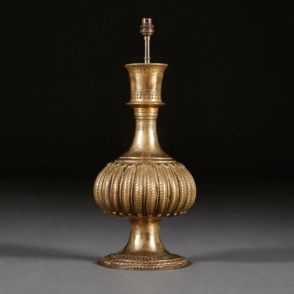 An early twentieth century Indian brass vessel with bulbous central section of gourd form, with flared neck and base. 

Please note that the lampshade is not included, and that this lamp is currently wired for the UK.