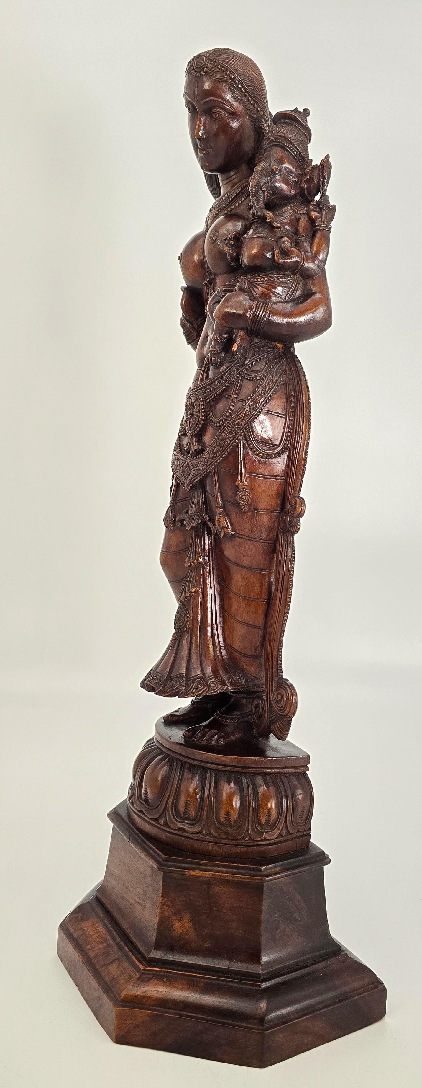 This superb hand carved sandalwood figure is Indian from the Raj period and dates to circa 1900.
It depicts the Hindu goddess Parvati, who represents love, fertility and devotion. 
Parvati is beautiful. She is semi-naked and very ornate in her