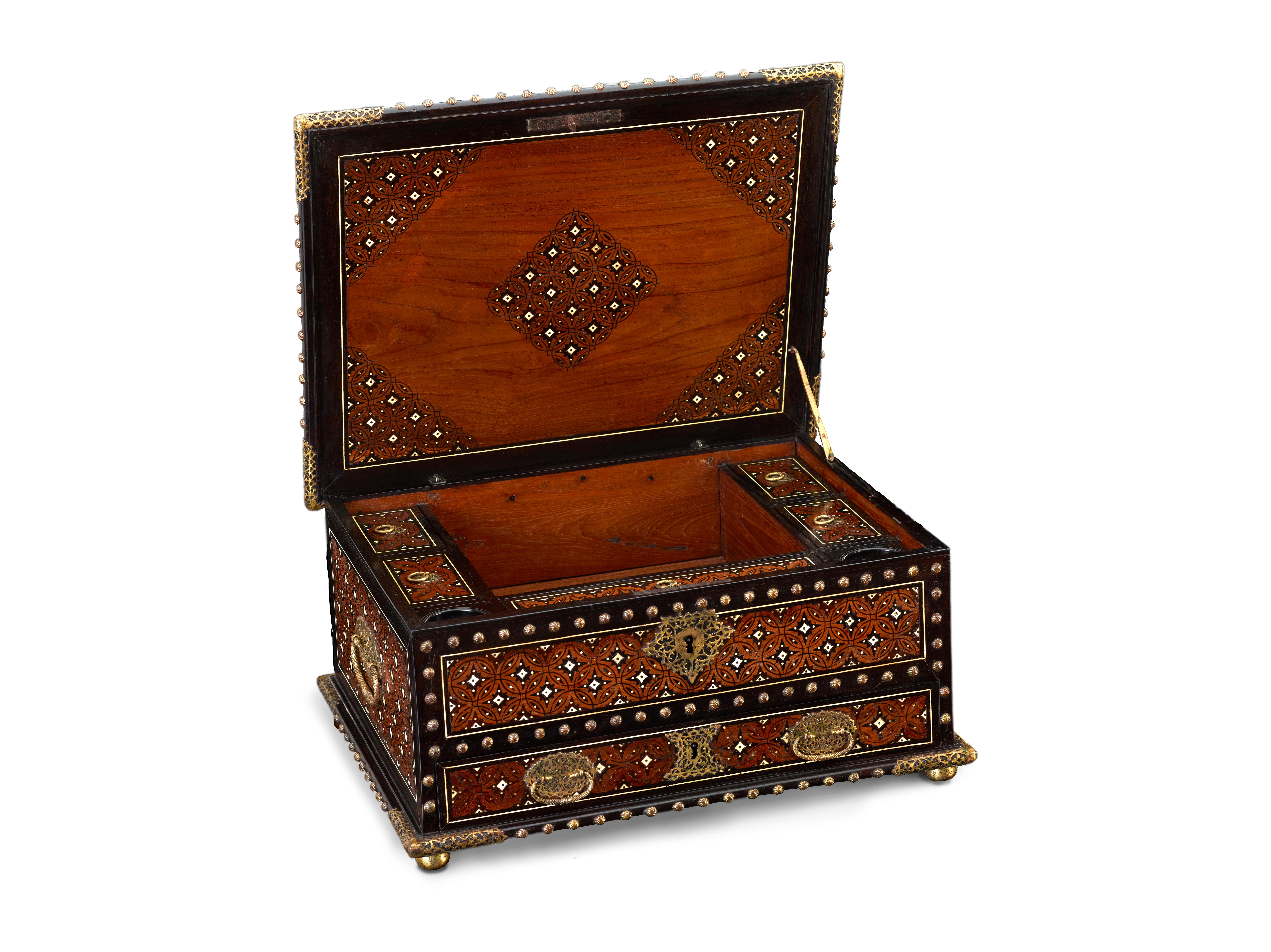 India, Goa, siglo XVII

La caja, en su conjunto con incrustaciones de un delicado dibujo en ébano y hueso en reservas de teca bordeadas de ébano tachonado de latón, es de forma oblonga. Las esquinas, la placa de la cerradura, las bisagras y las