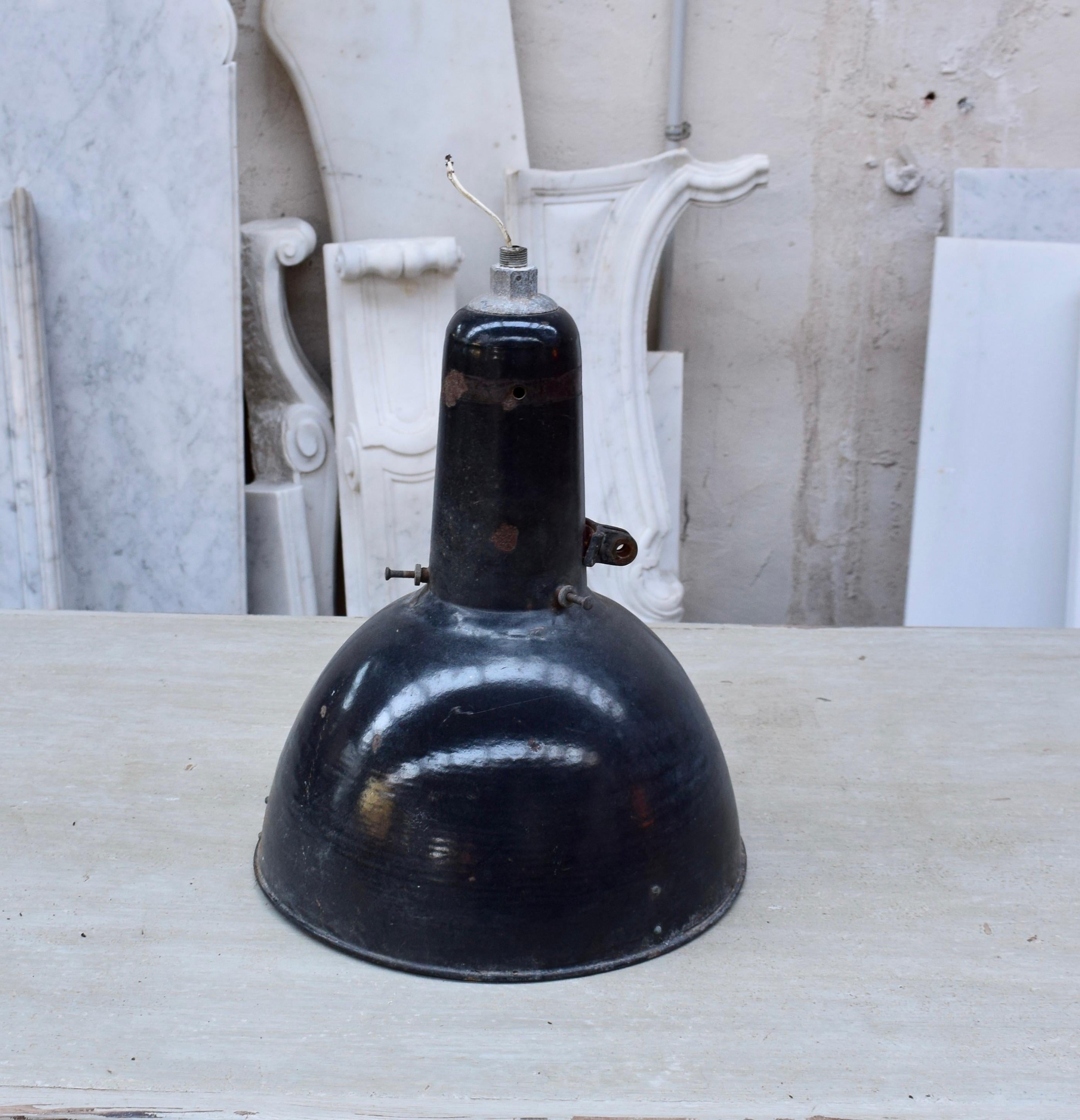 A pendant lamp made in Spain during the 1930s. This light would have previously been used in factories. It is made from enamelled metal, they are in their original condition with signs of age and usage. Each lamp has a black exterior and a white