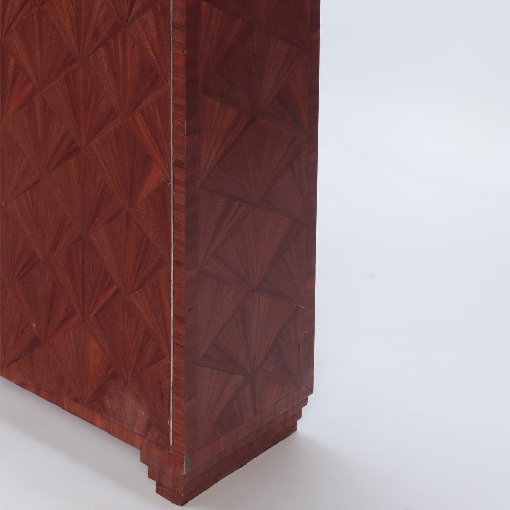 Ein eingelegter Schrank in der Art von Jean-Michel Frank. Zeitgenössisch. Das Gehäuse mit geometrischer Intarsienarbeit aus Stroh, zwei Türen, die sich zu zwei Einlegeböden öffnen, steht auf vier quadratischen, konischen Füßen. 