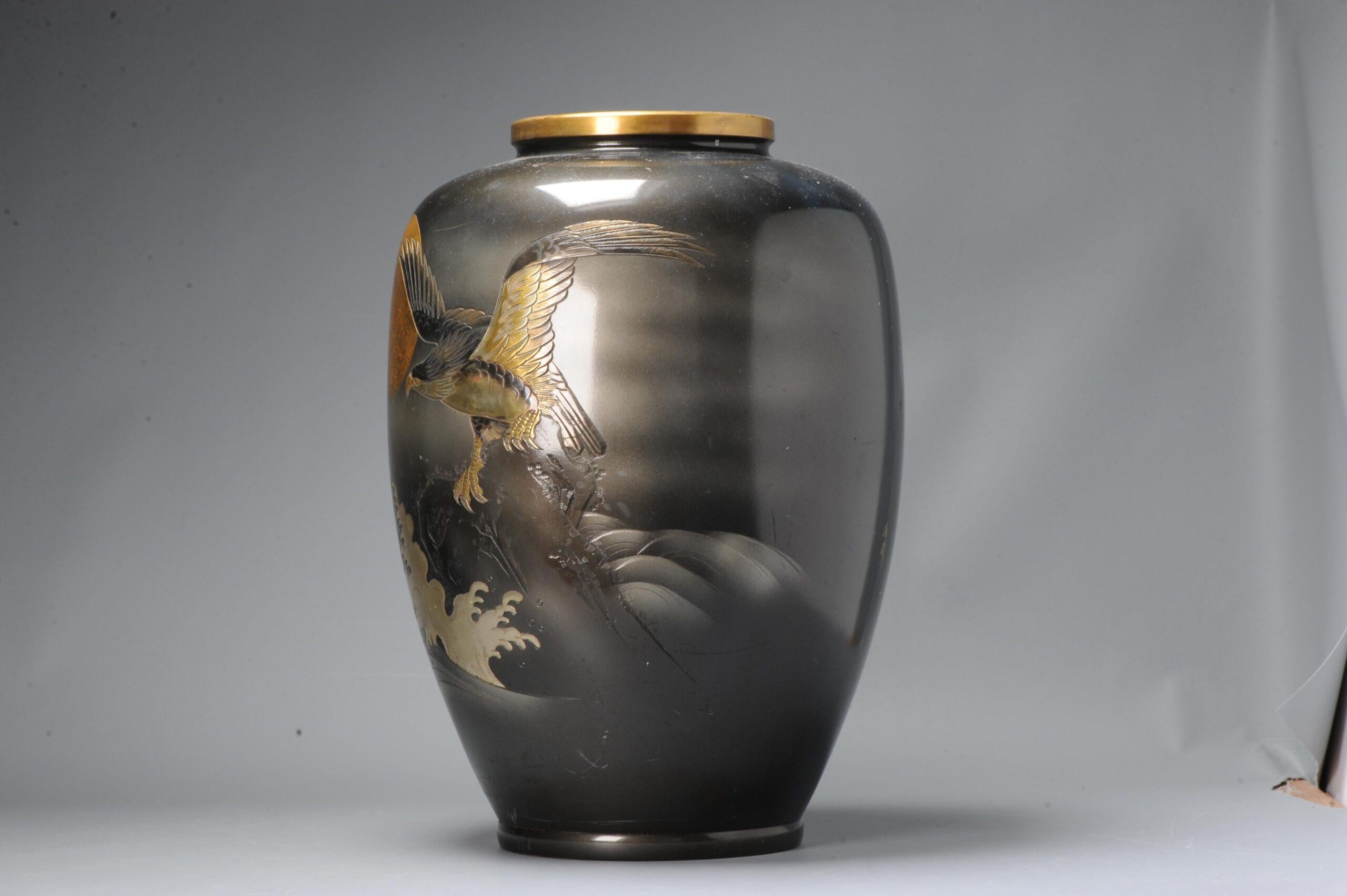 Te presentamos un excepcional jarrón japonés Shibuichi de principios del siglo XX, adornado con una llamativa escena de una magnífica ave rapaz. El jarrón lleva la marca Seifu en el lateral, lo que indica que es obra de un hábil artista de la