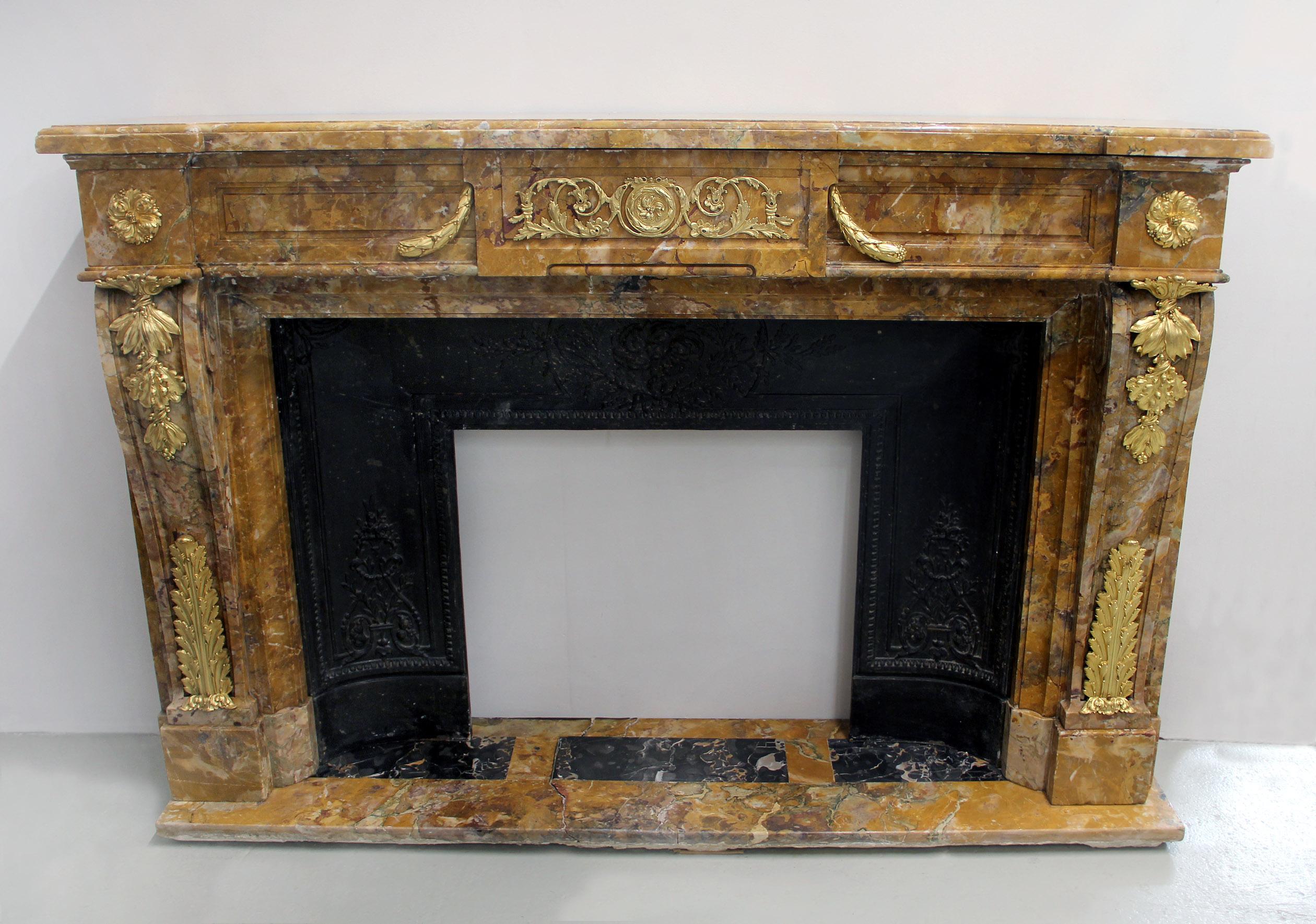 Intéressante et rare cheminée en marbre Giallo di Siena montée en bronze doré de la fin du XIXe siècle

La tablette du manteau en marbre mouluré est surmontée d'une frise centrale minutieusement sculptée de vignes en volutes et centrée d'un