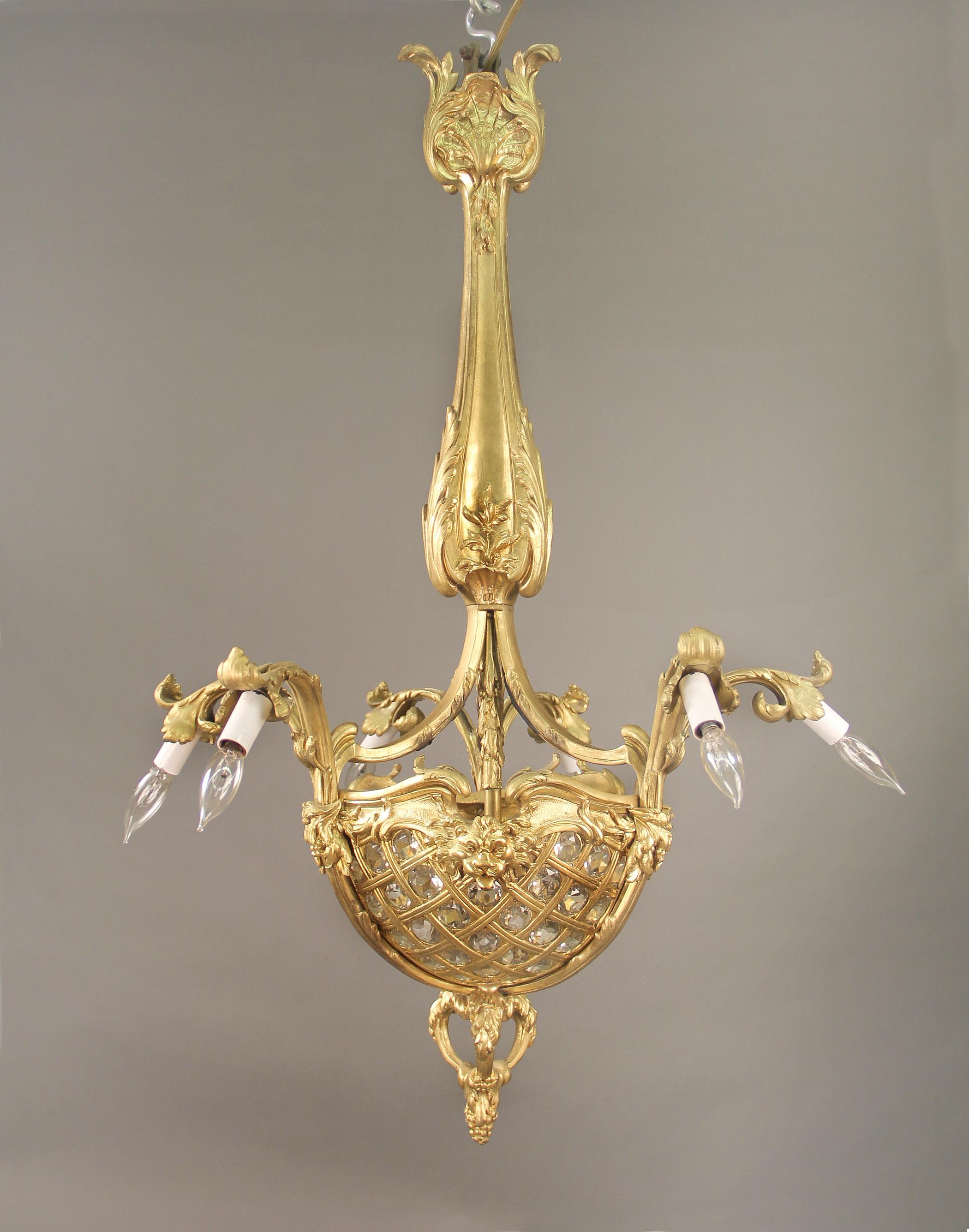An Interesting Early 20th Century Gilt Bronze Nine Light Chandelier

The crown beautifully designed with sea shells, the body leading down to a three sided beaded basket centered by large lion masks, finishing with a large finial bottom with