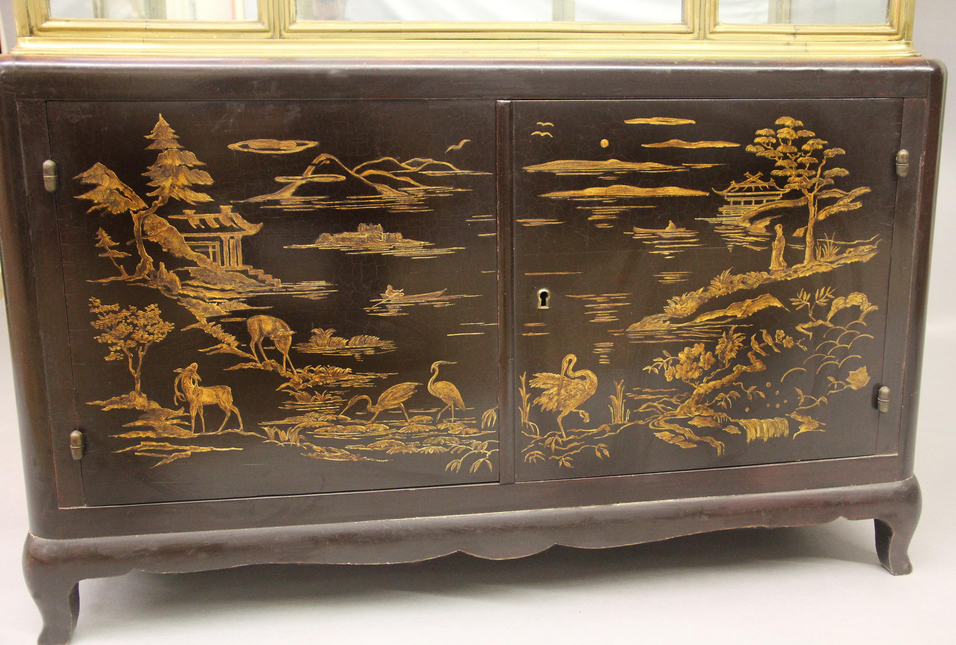 An interesting late 19th century transitional style gilt bronze and lacquer vitrine cabinet.

The large gilt bronze and all glass single door vitrine above a fine two door lacquered cabinet designed as a landscape scene with people, deer and