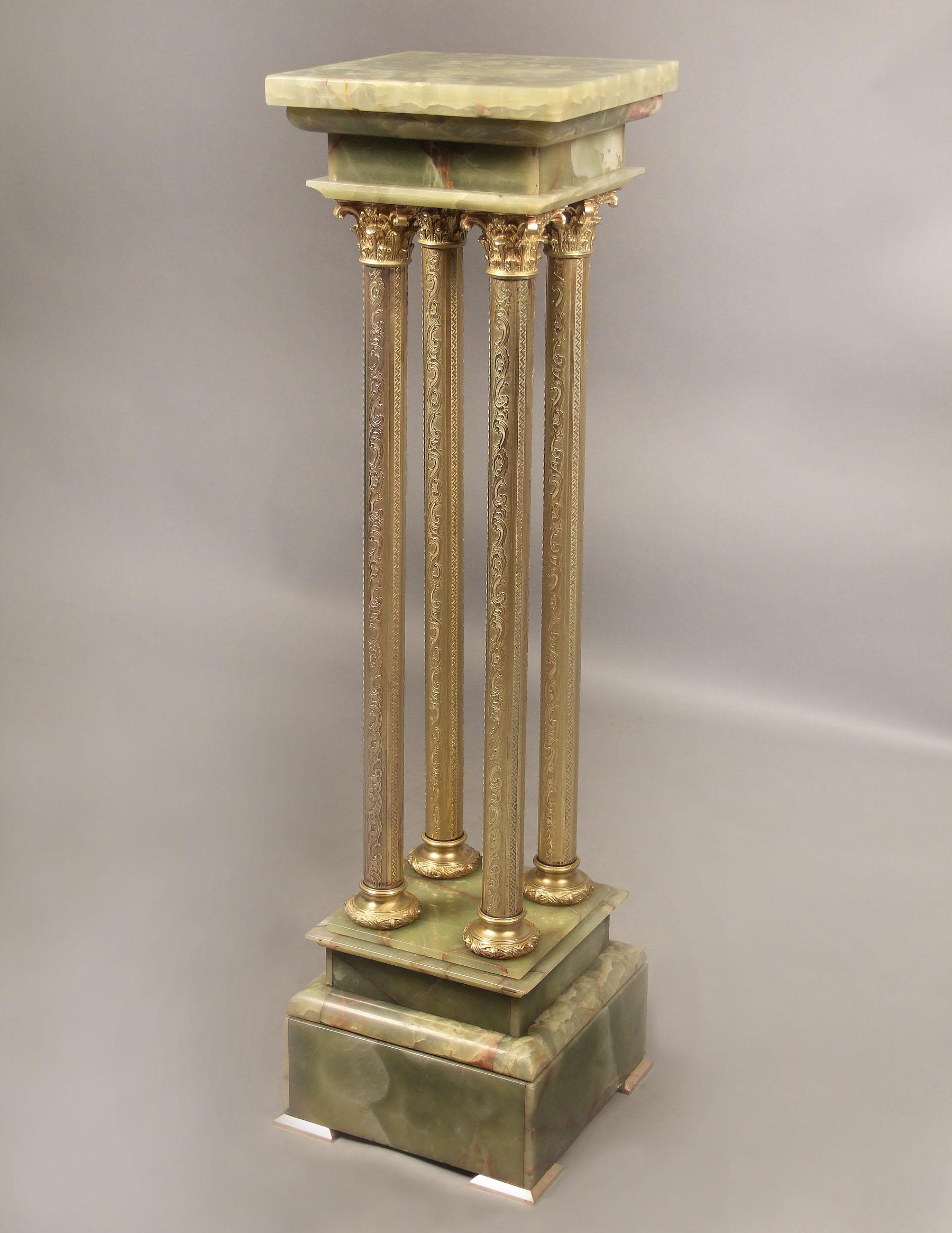 An Interesting Late 19th Century Gilt Bronze and Onyx Pedestal

Square onyx swivel top above four finely chiseled and designed gilt bronze pillars, standing on a tiered base on bronze feet.