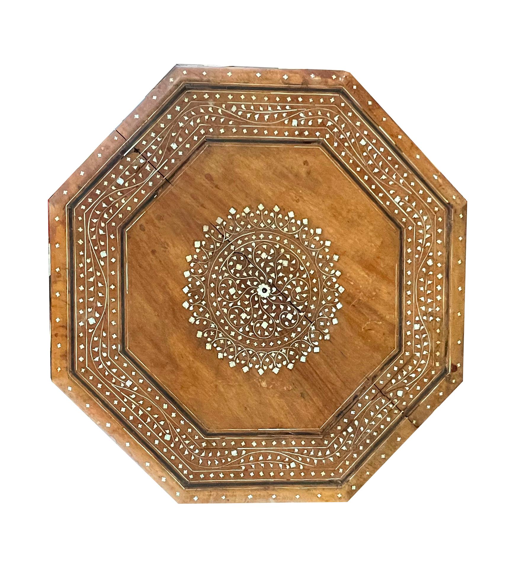 originally used as traveling tea tables for the British in India; the octagonal top with round central medallion within a border of meandering vines; raised on a hinged base with arabesque spandrels; perfect as a drinks table that can be