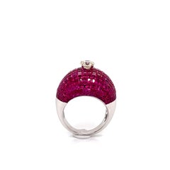 An Invisibly Set Ruby Ring of 22.17 Carats, Centering a 0.73-Carat Diamond