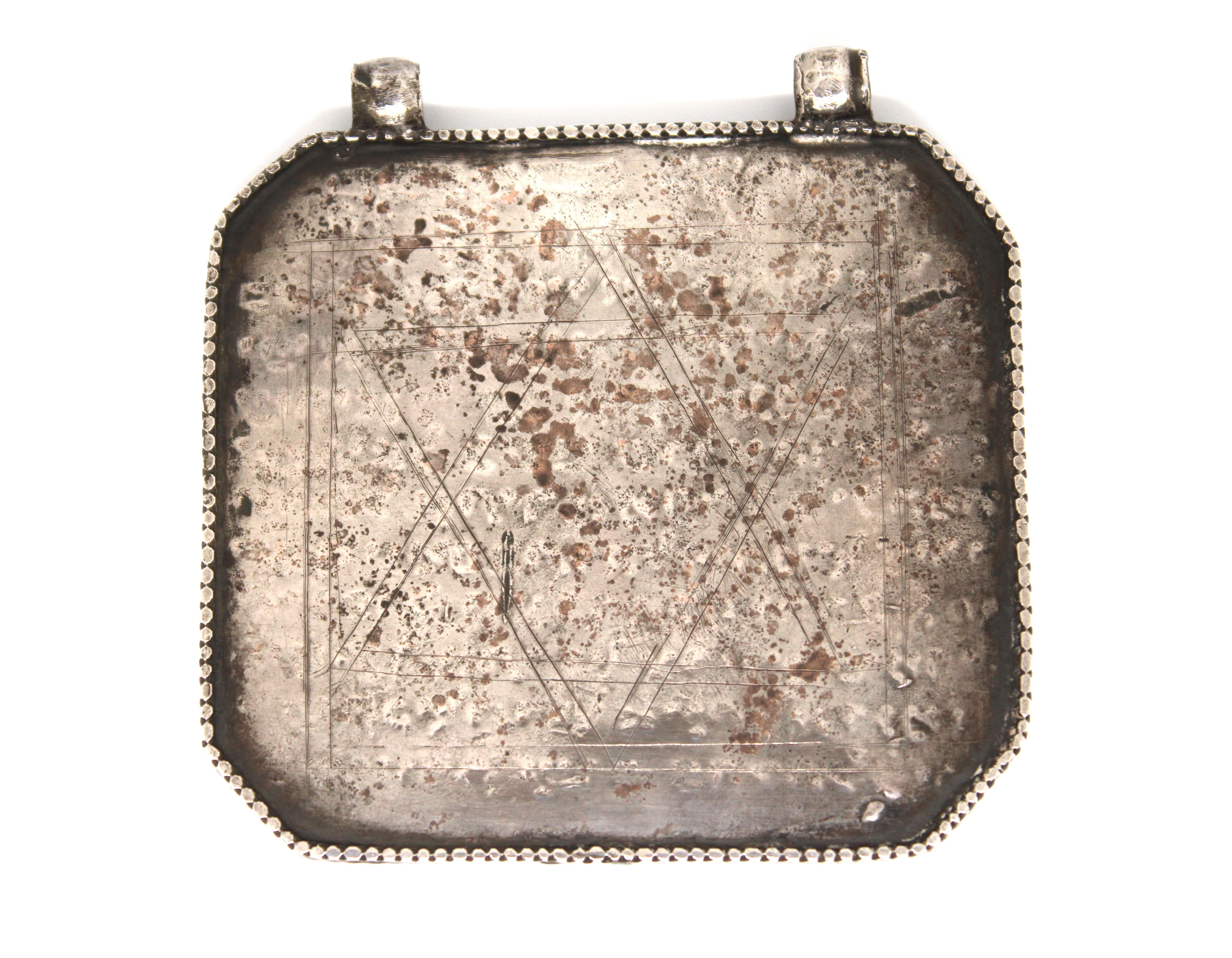 Cette amulette en argent d'Irak, exceptionnelle et d'une taille inhabituelle, est un puissant artefact de mystique juive et de dévotion personnelle. Fabriquée avec le plus grand soin, l'amulette se présente sous la forme d'une imposante tablette