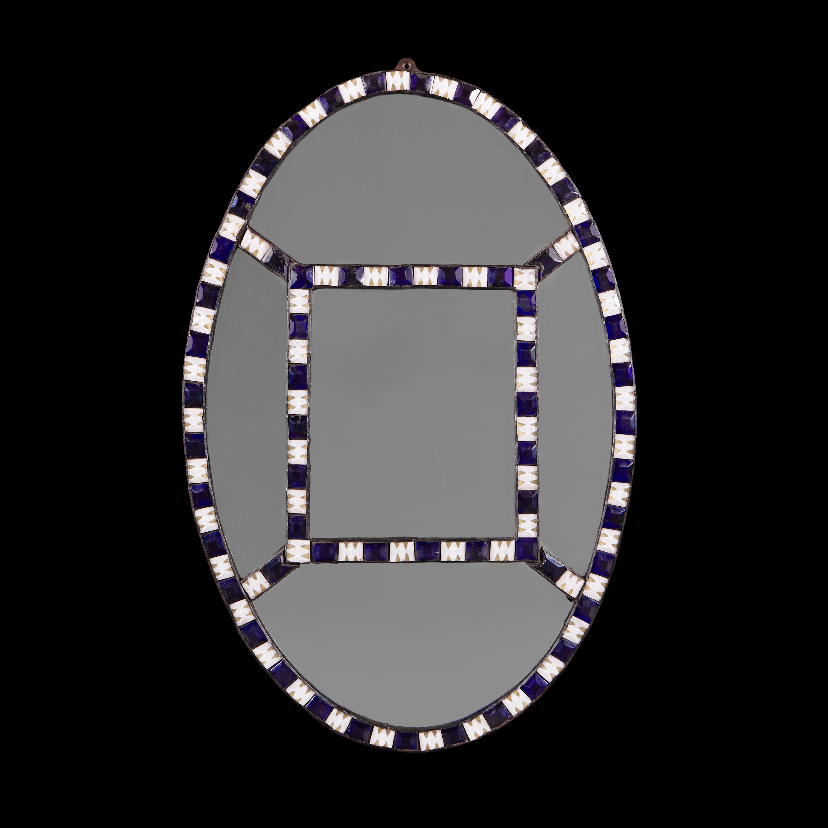 Ireland, circa 1930
An early twentieth century Irish beaded mirror in the eighteenth century style, of oval form with blue and clear cut glass beaded border, the inner rectangular mirror plate and border branching off to each corner.

Height    