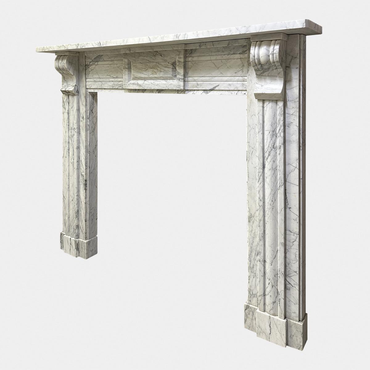 A well drawn and proportioned early 19th century antique Irish fireplace from the Regency period. The pilaster jambs with cushion mould panels to front,  with conforming detail on brackets. The large fielded panelled tablet with cushion moulded