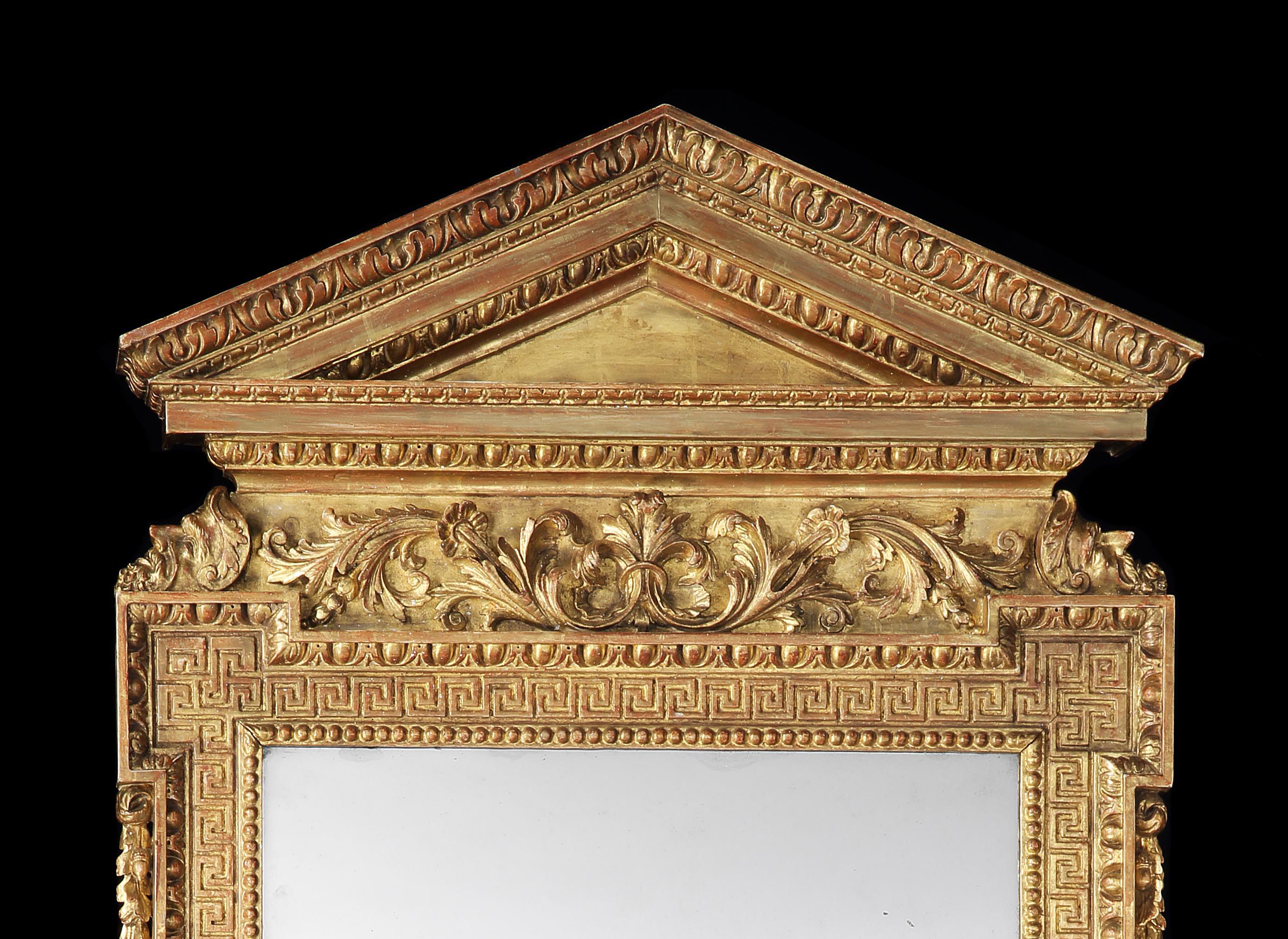 A rare Irish George II carved giltwood pier glass, the architectural top with carved egg and dart and acanthus mouldings, above a carved central panel of flowing acanthus, flanked by opposing carved head ends, to a rectangular plate with a Greek key