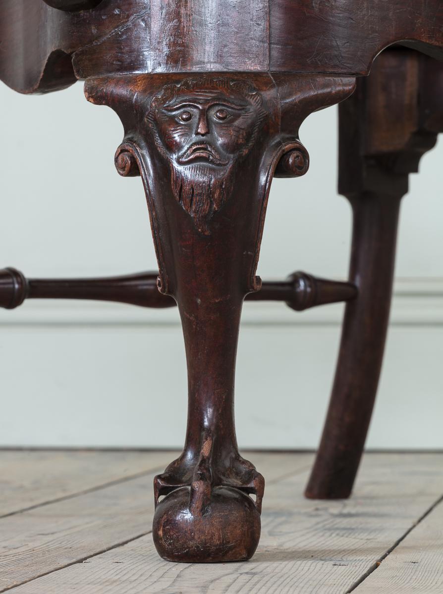 An Irish George II Red Walnut Open Armchair

The back with carved crest rail and solid but intricately shaped back splat, with unusually drawn and angular arm, reminiscent of the synonymous but softer crook arm shape. On cabriole legs, with carved