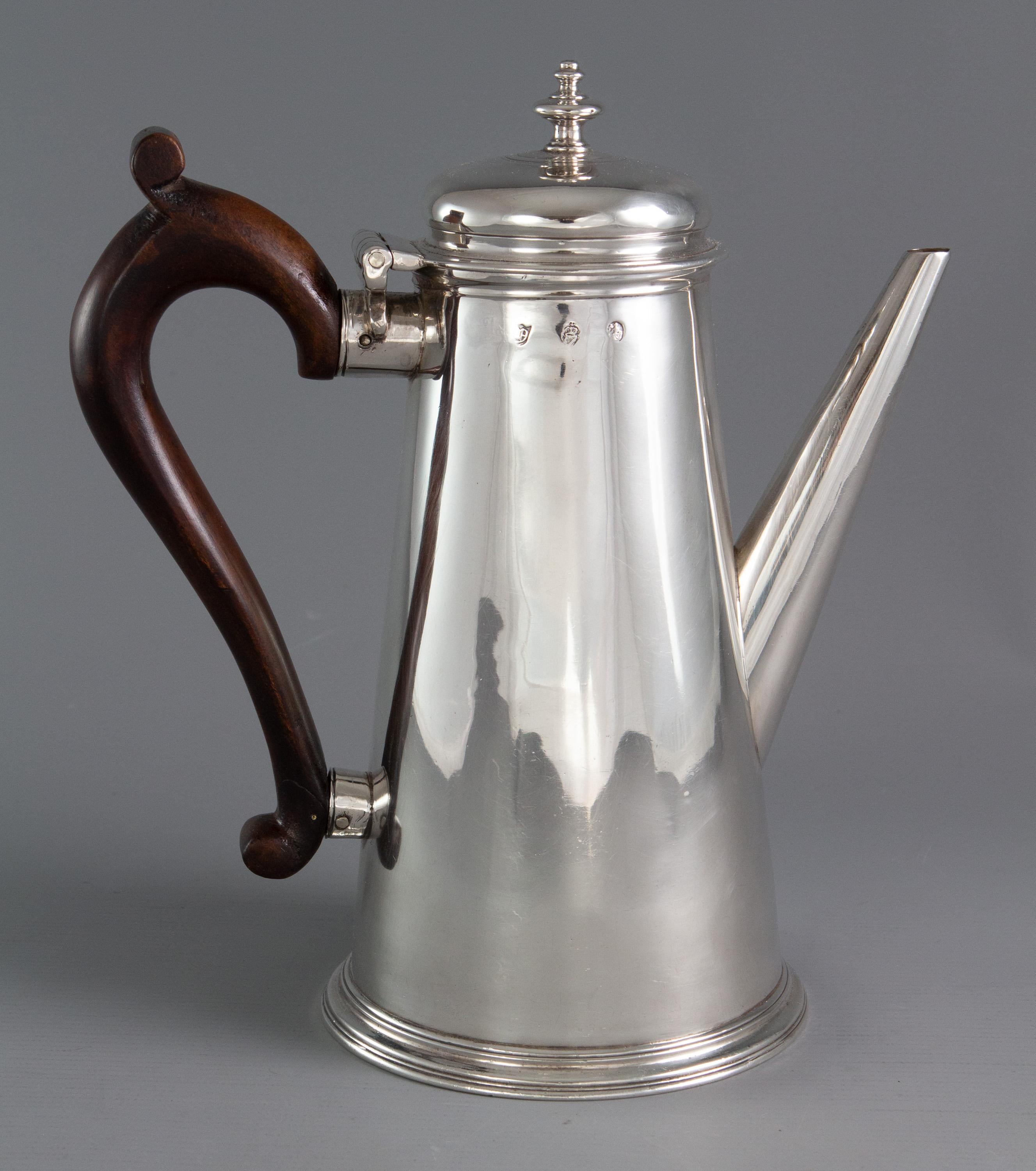 A rare George II Irish silver coffee pot with tapering sides, with a raised domed lid and compressed acorn finial. A tapering straight spout and wooden handle.

Hallmarked for Dublin 1732 by either the Limerick silversmith John Robinson or the