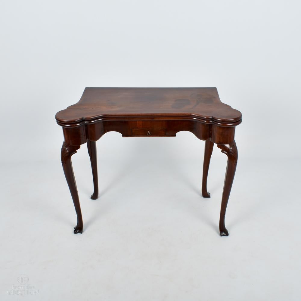 An Irish Mahogany Fold out games table with oval counter holders and a small drawer to the front. From the George III period circa 1780, Irish with pad feet and a green baize.
