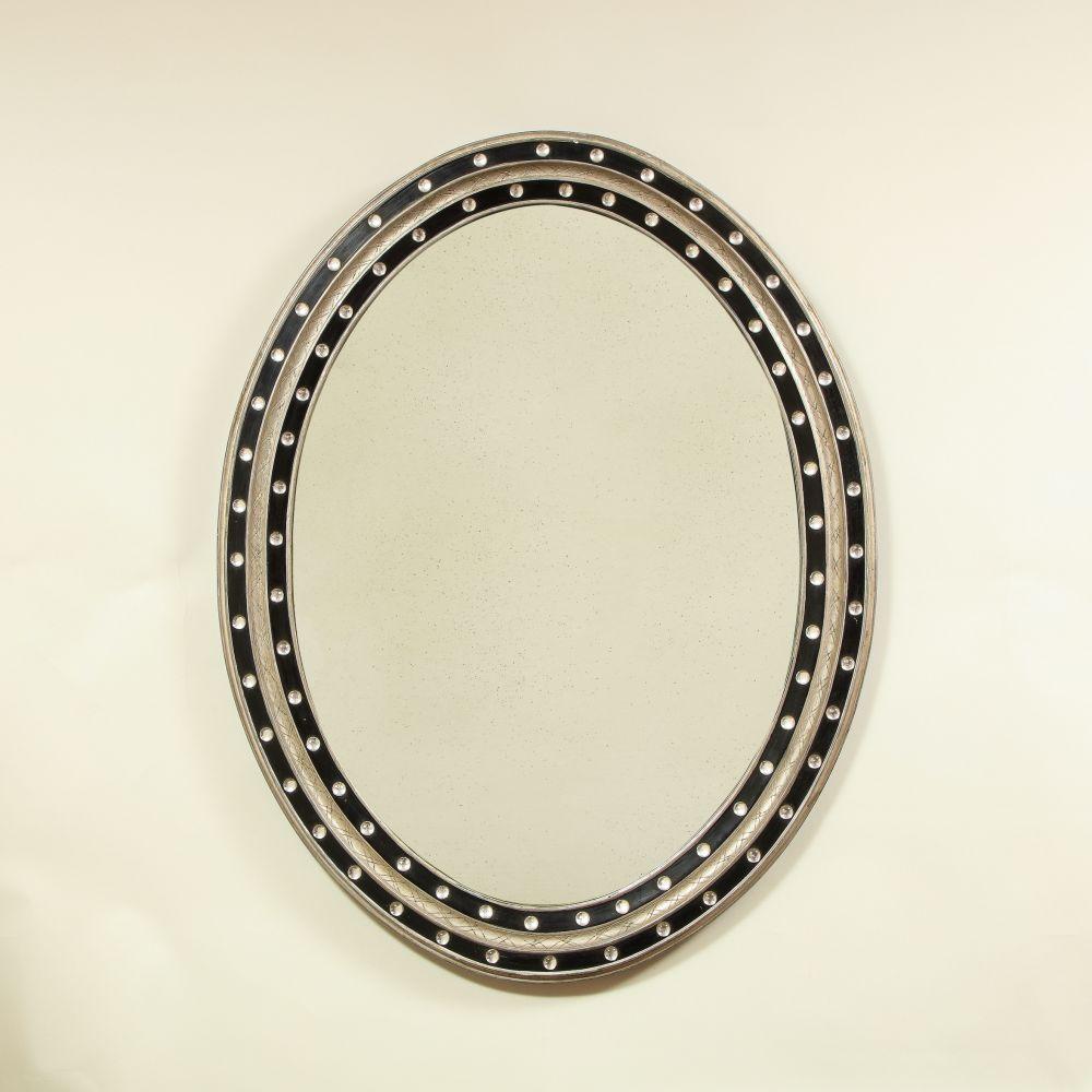 The antiqued oval mirror plate within a conforming frame of an incised silver gilt set between blue borders applied with glass beads.
