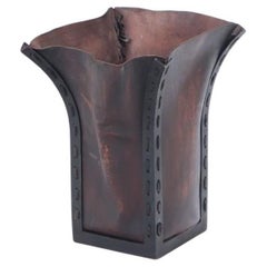 An iron and leather waste basket.