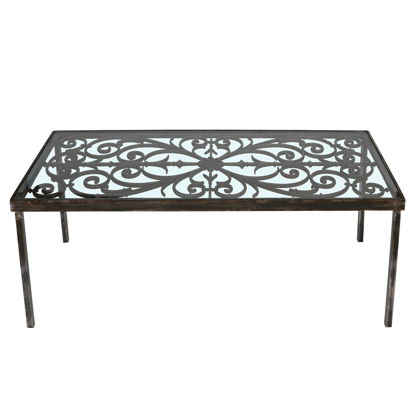 This cocktail table is somewhat rustic yet refined at the same time.  The base is wrought iron, featuring a lovely scrolled and floral design, and the top is clear glass.  