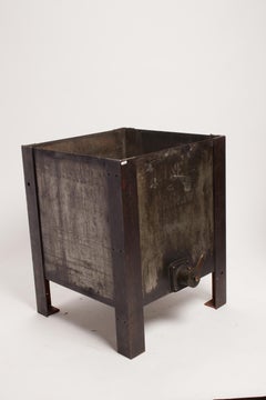 An iron industrial oil container, reused as flower box, United States early 1900