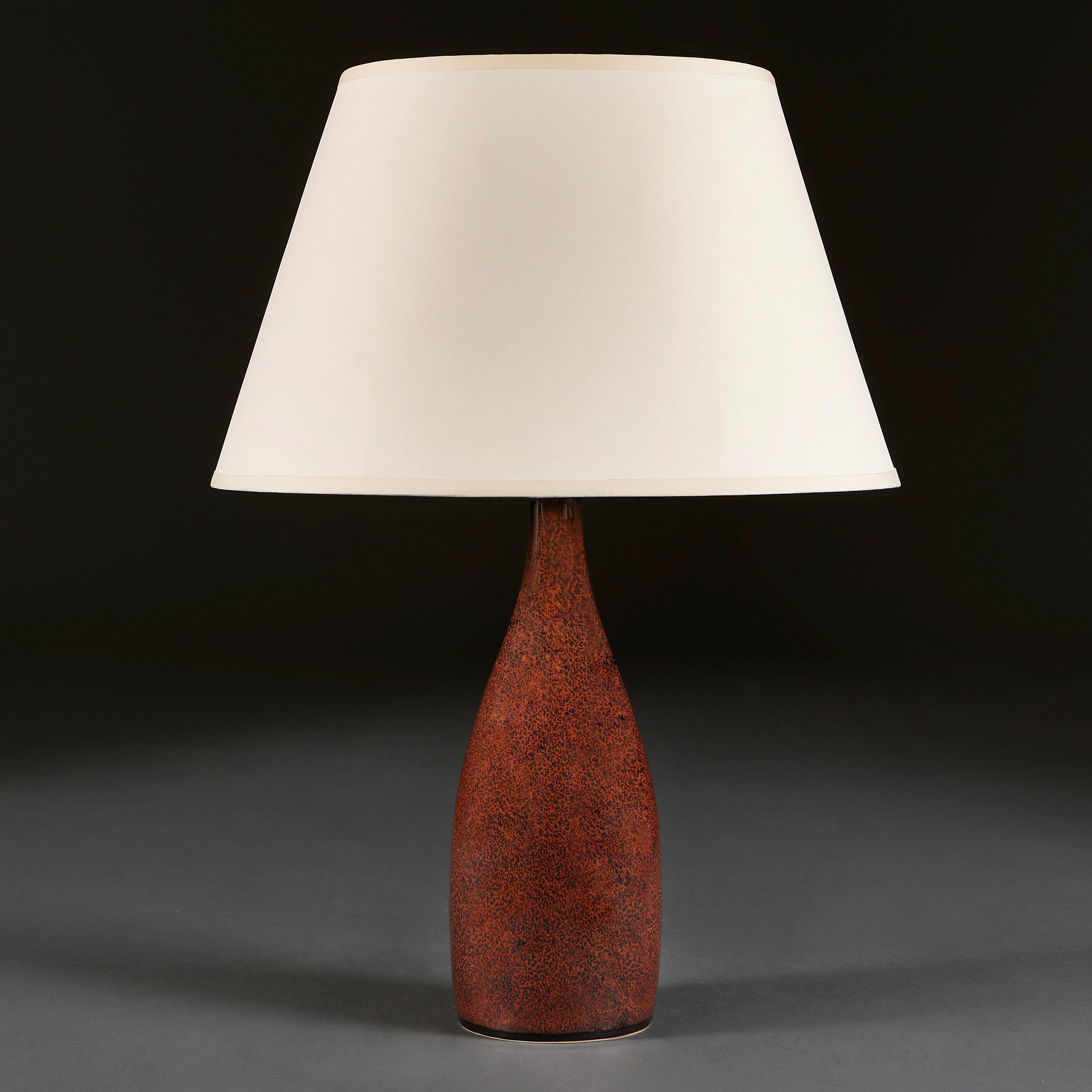 England, circa 20th century 

A red ironspot vase with bottle neck, thrown from white stoneware, now converted as a lamp.

Height 32.00cm
Diameter 12.50cm

Please note: This is currently wired for the UK with BC bulb fitting, twisted bronze