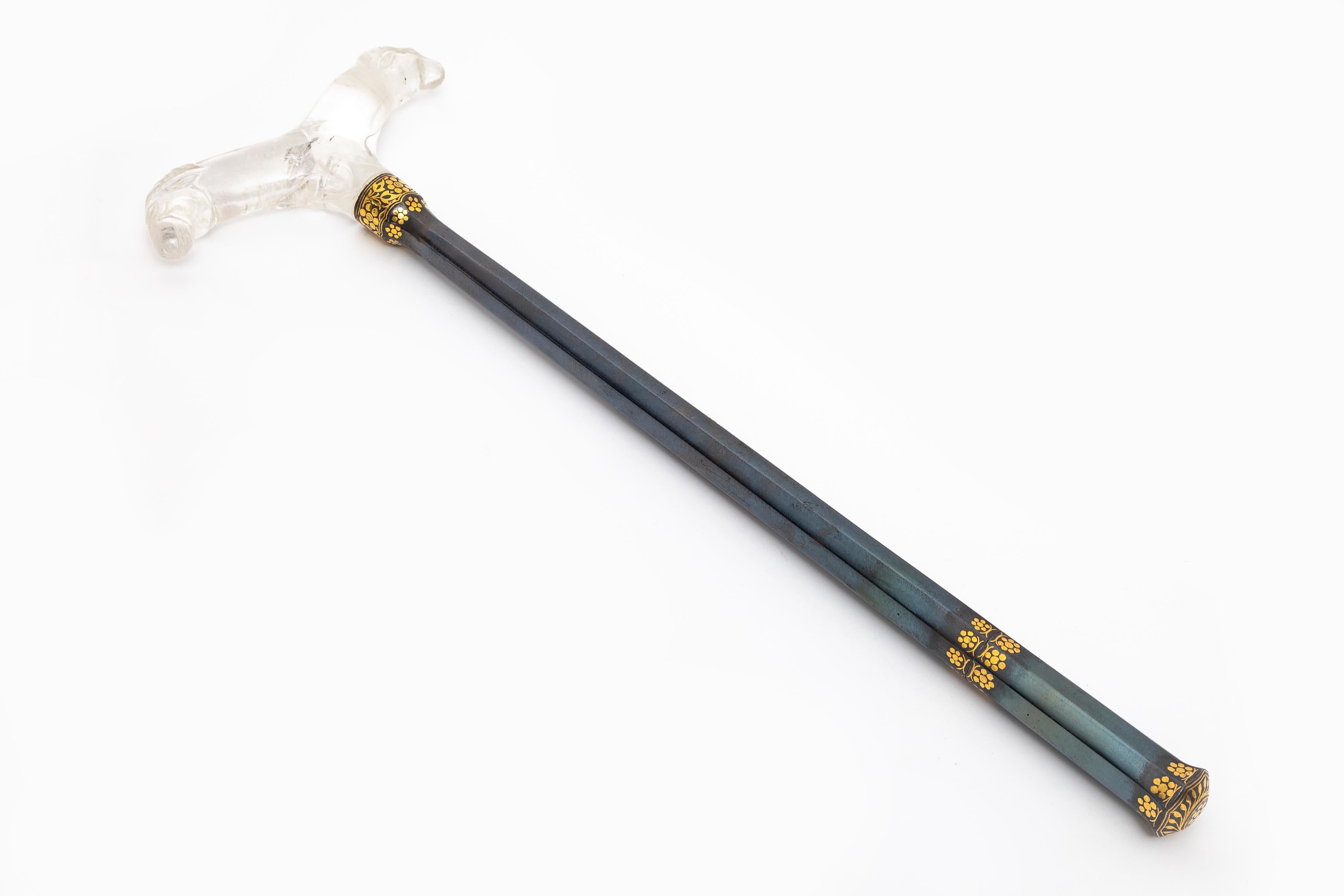 An Incredible and Quite Rare 18th/19th Century Islamic/Mogul Blued Steel and Gold Inlay Rock Crystal Double Rams Head Handle Cane/Swagger Stick. This elegant cane features blued steel adorned with a delicate floral motif and gold inlay, complemented