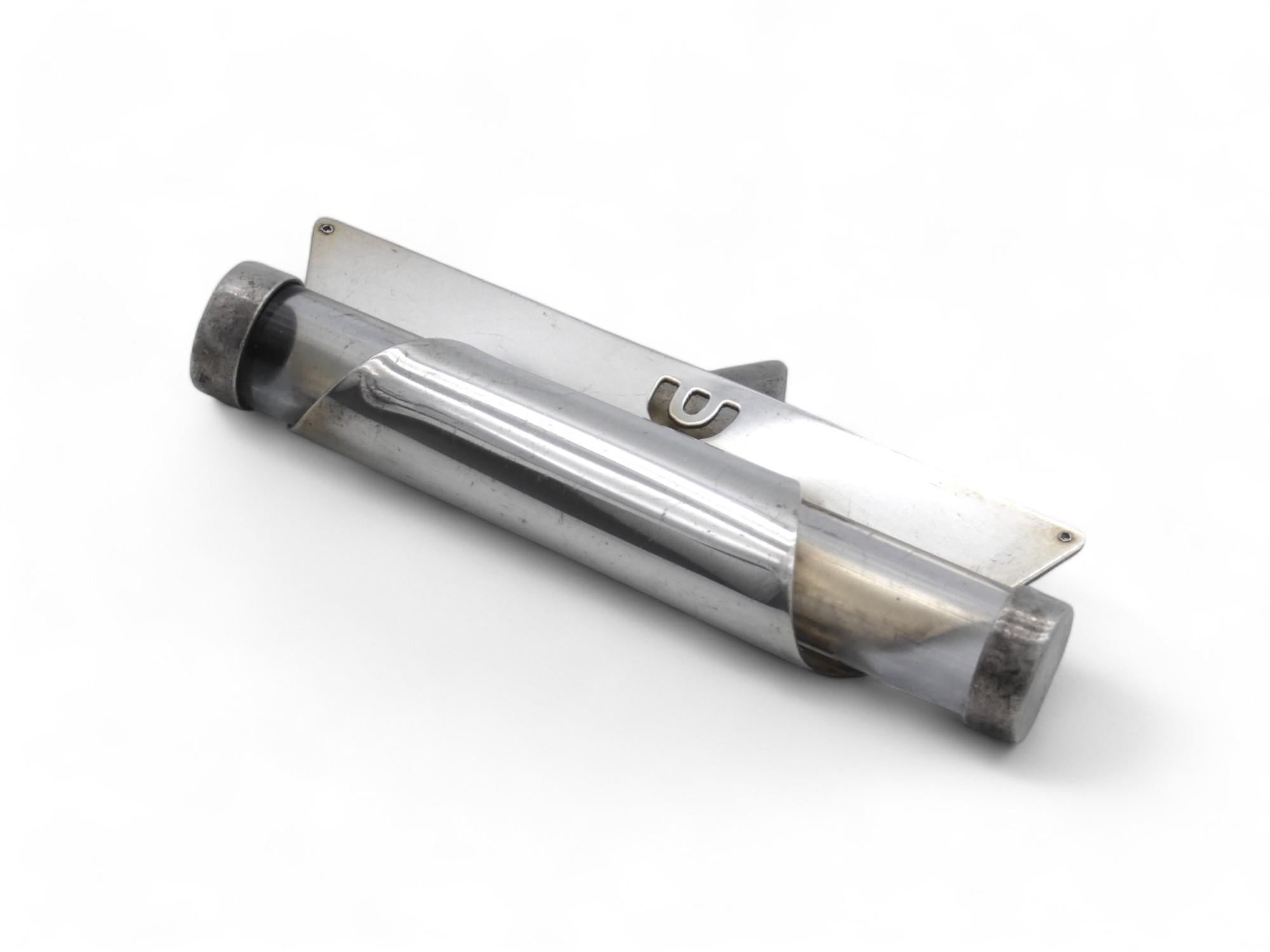 Una Mezuzah israelí moderna de Noam, circa 2000.

La caja de la Mezuzá tiene un estilo posmoderno evidente por sus formas geométricas.

El estuche está formado por una pieza triangular de plata que se dobla en la punta y se introduce en el extremo